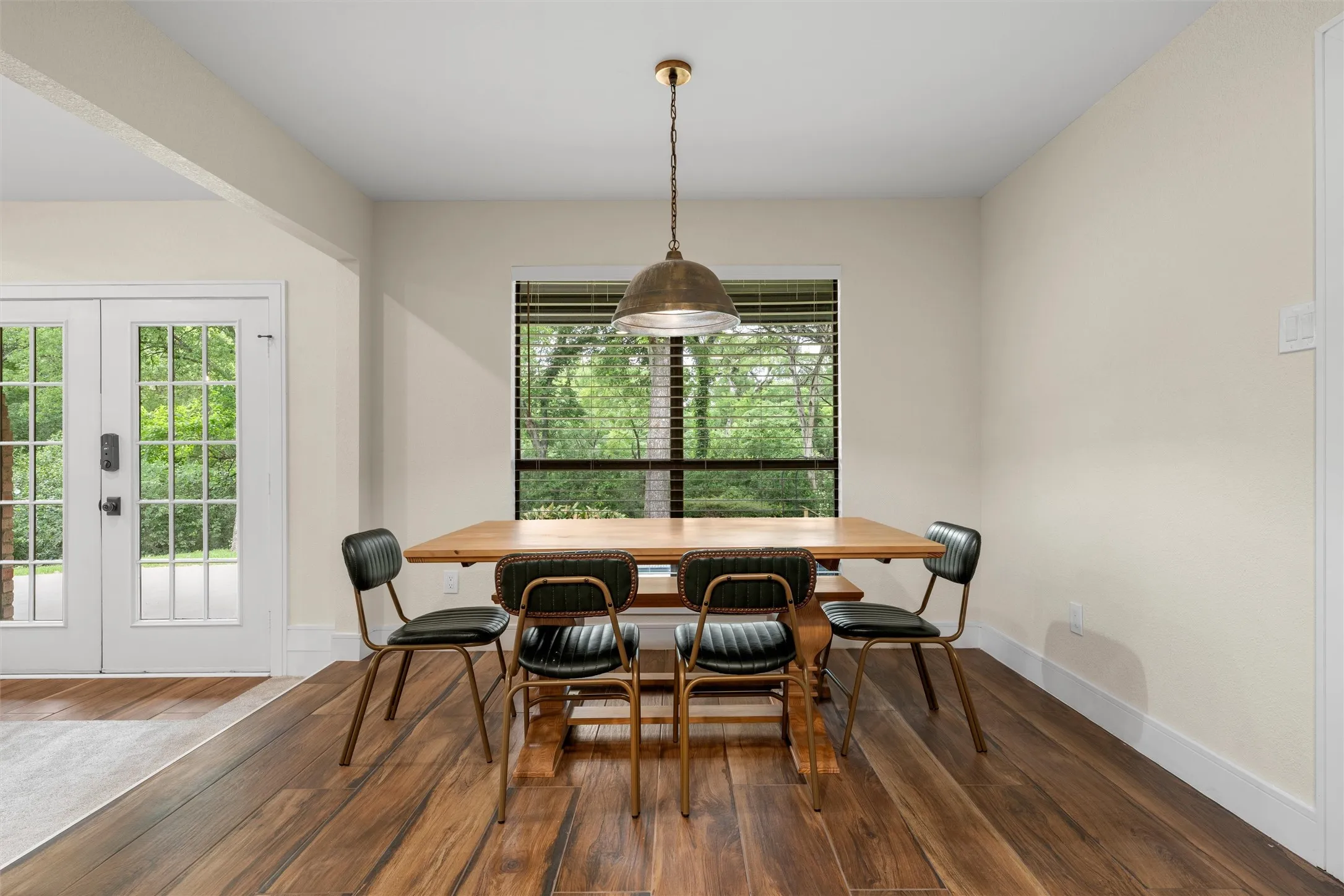 Dining area featuring wood-finish flooring and a rectangular window with blinds