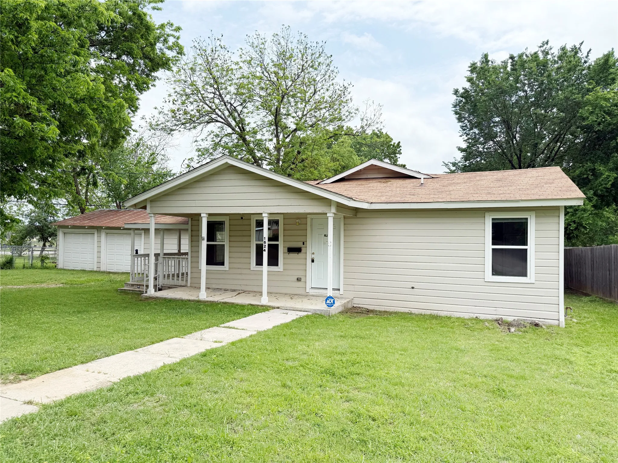 Single-story property featuring light-colored siding and a front porch with white columns