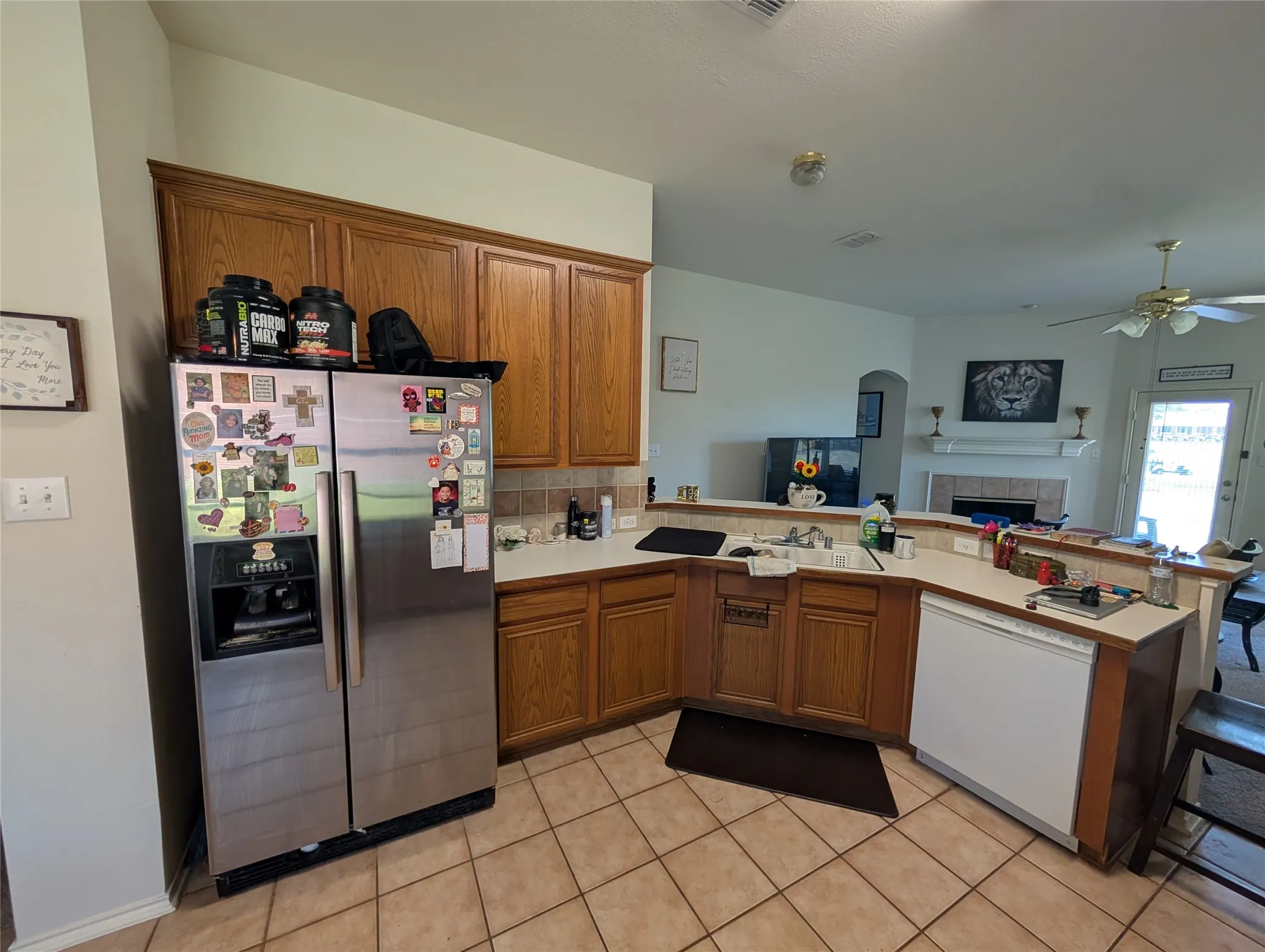 Kitchen featuring wood-finish cabinetry, tile flooring, and a stone-look backsplash