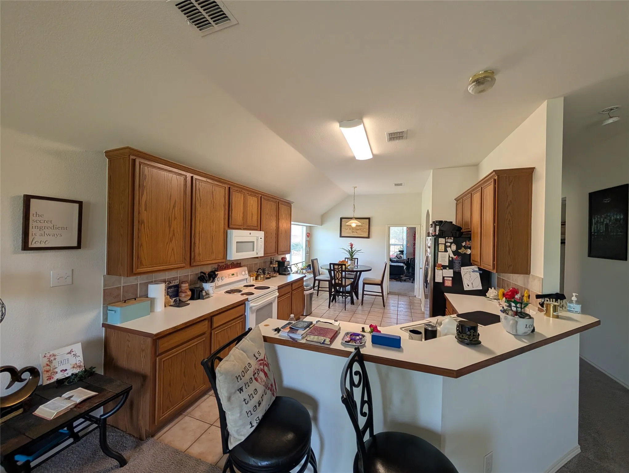 Well-appointed kitchen featuring wood-finish cabinetry, a white electric range, and a built-in microwave