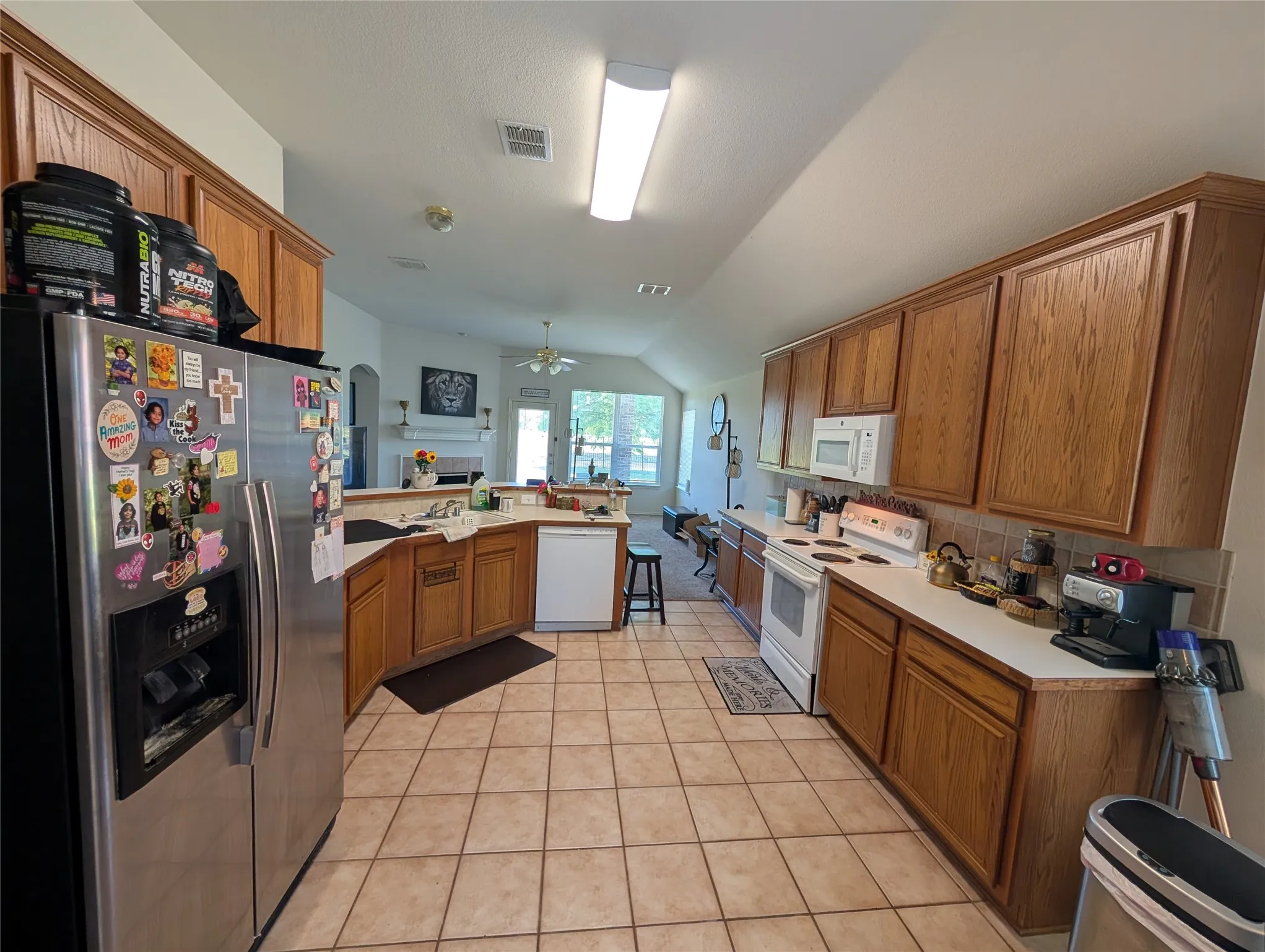 Kitchen featuring wood-finish cabinetry, tile flooring, and a white countertop