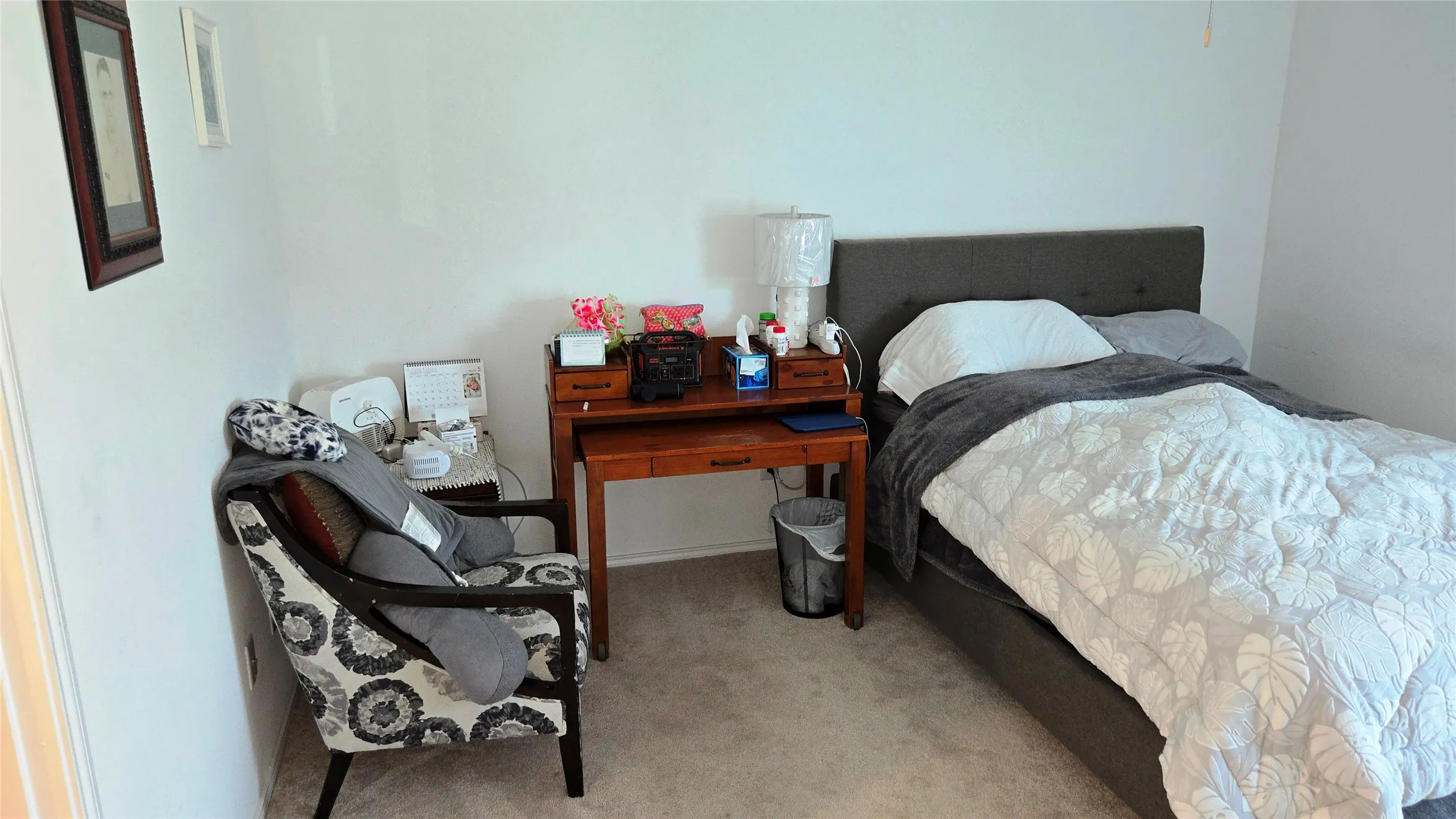 Carpeted bedroom featuring white walls and a built-in ceiling fan
