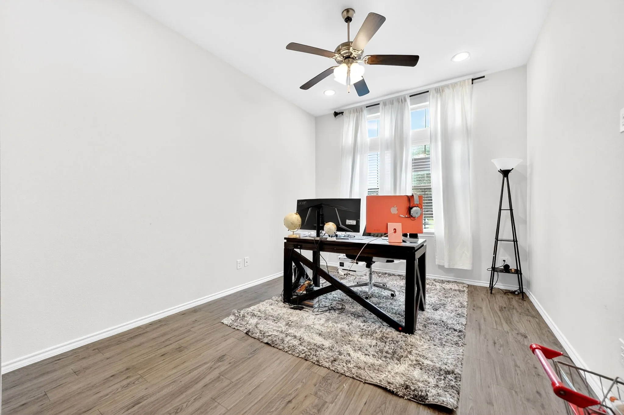 Room featuring wood-finish flooring, a ceiling fan with integrated lighting, and recessed ceiling lights