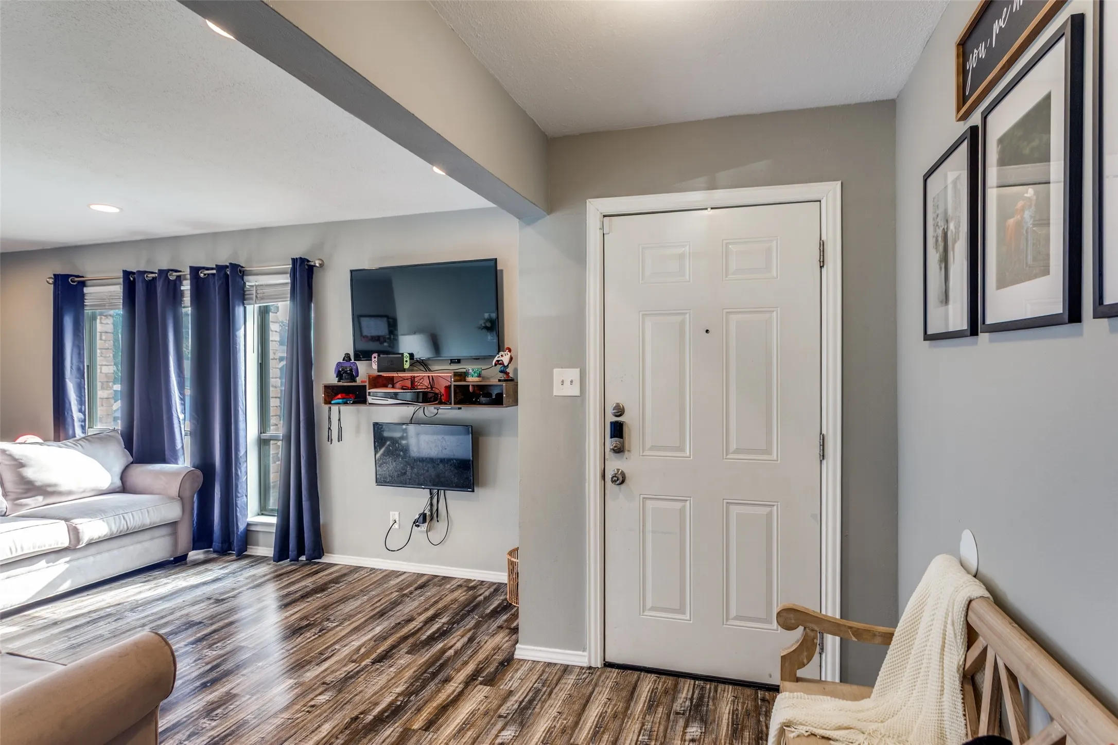 Entryway featuring a paneled door with smart lock, wood-finish flooring, and recessed ceiling lighting