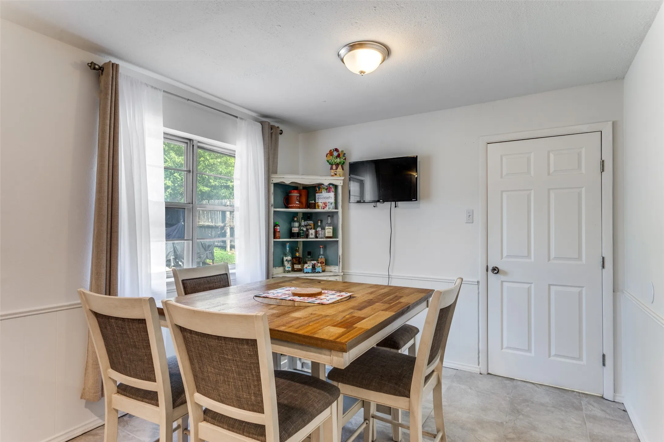 Dining area featuring a window with natural light, tiled flooring
