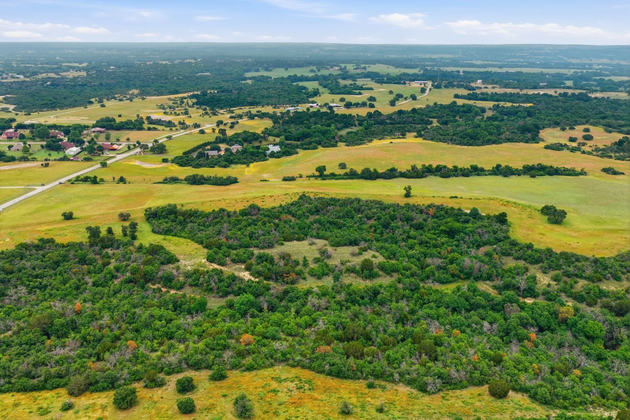 From the sky, the property’s natural beauty truly shines — rolling acreage, lush tree coverage, and panoramic rural views combine to create an unforgettable setting.
