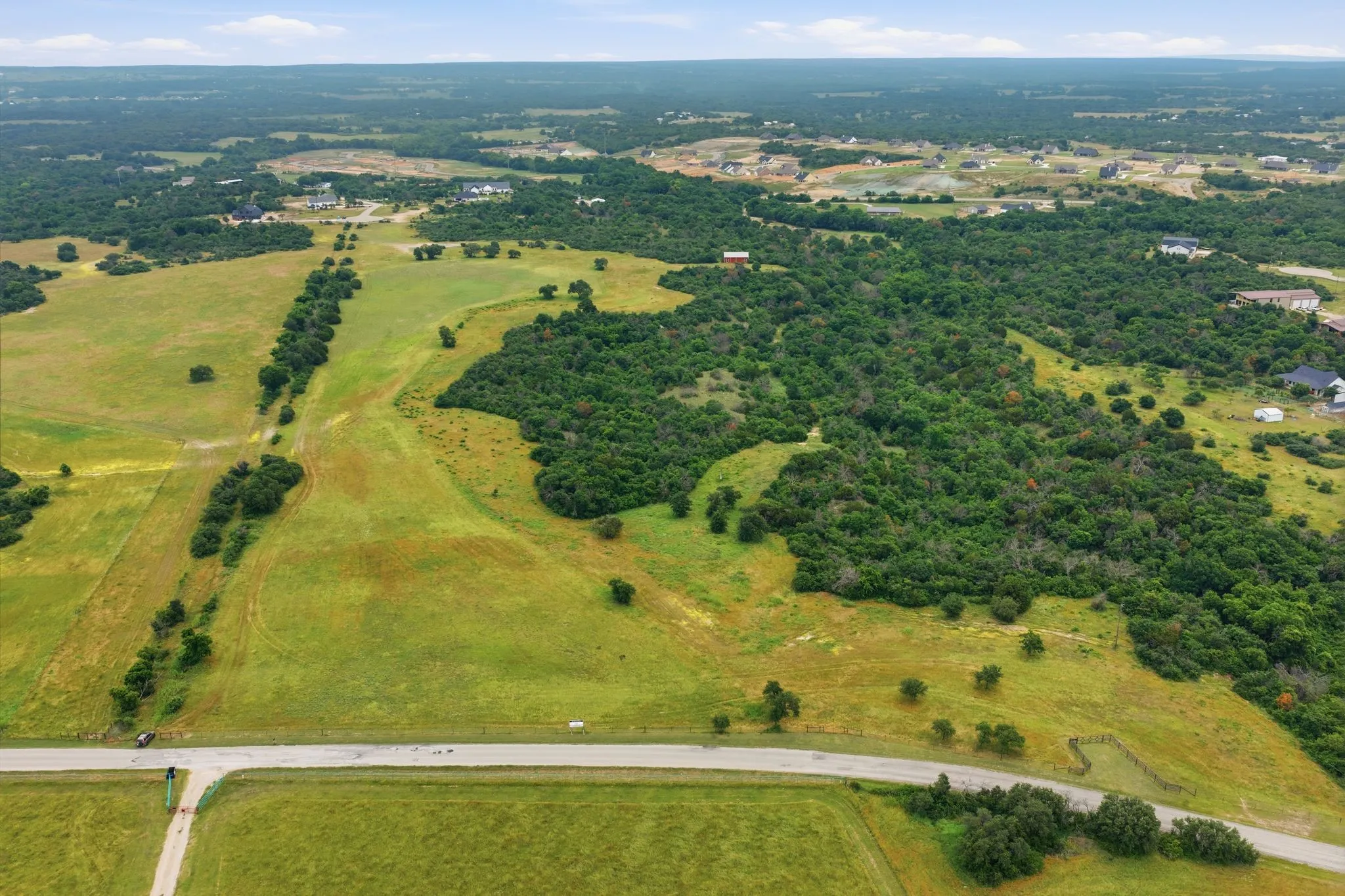 From above, this remarkable 54-acre retreat reveals a perfect blend of open pastureland and towering trees, offering privacy, beauty, and endless possibilities.