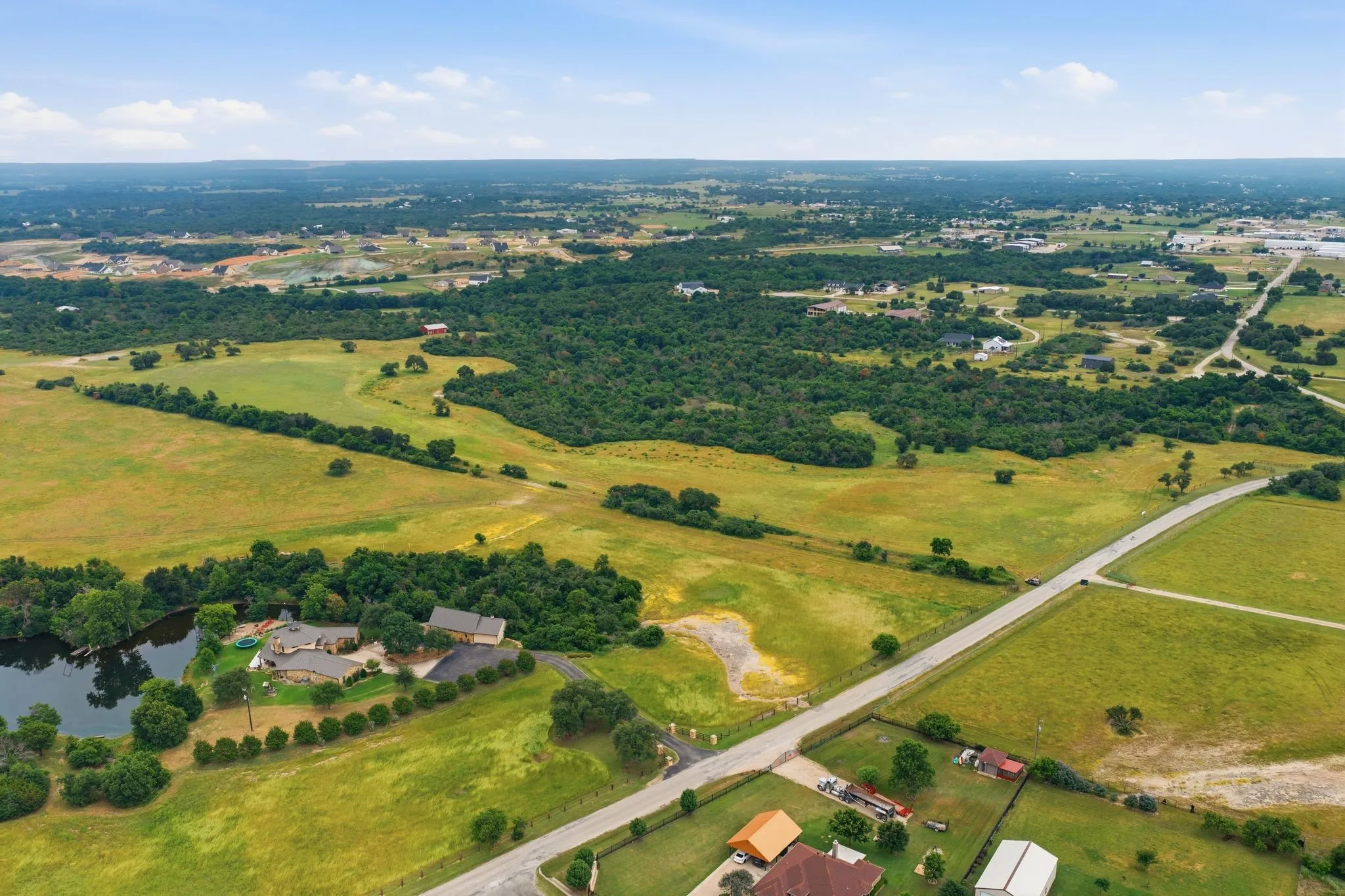 The aerial imagery beautifully showcases the property’s sweeping terrain and mature tree lines, creating the ideal backdrop for a private ranch or future estate.