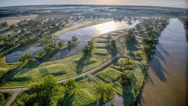 Expansive land parcel featuring a riverfront, multiple waterways, abundant mature trees, and a developed roadway system