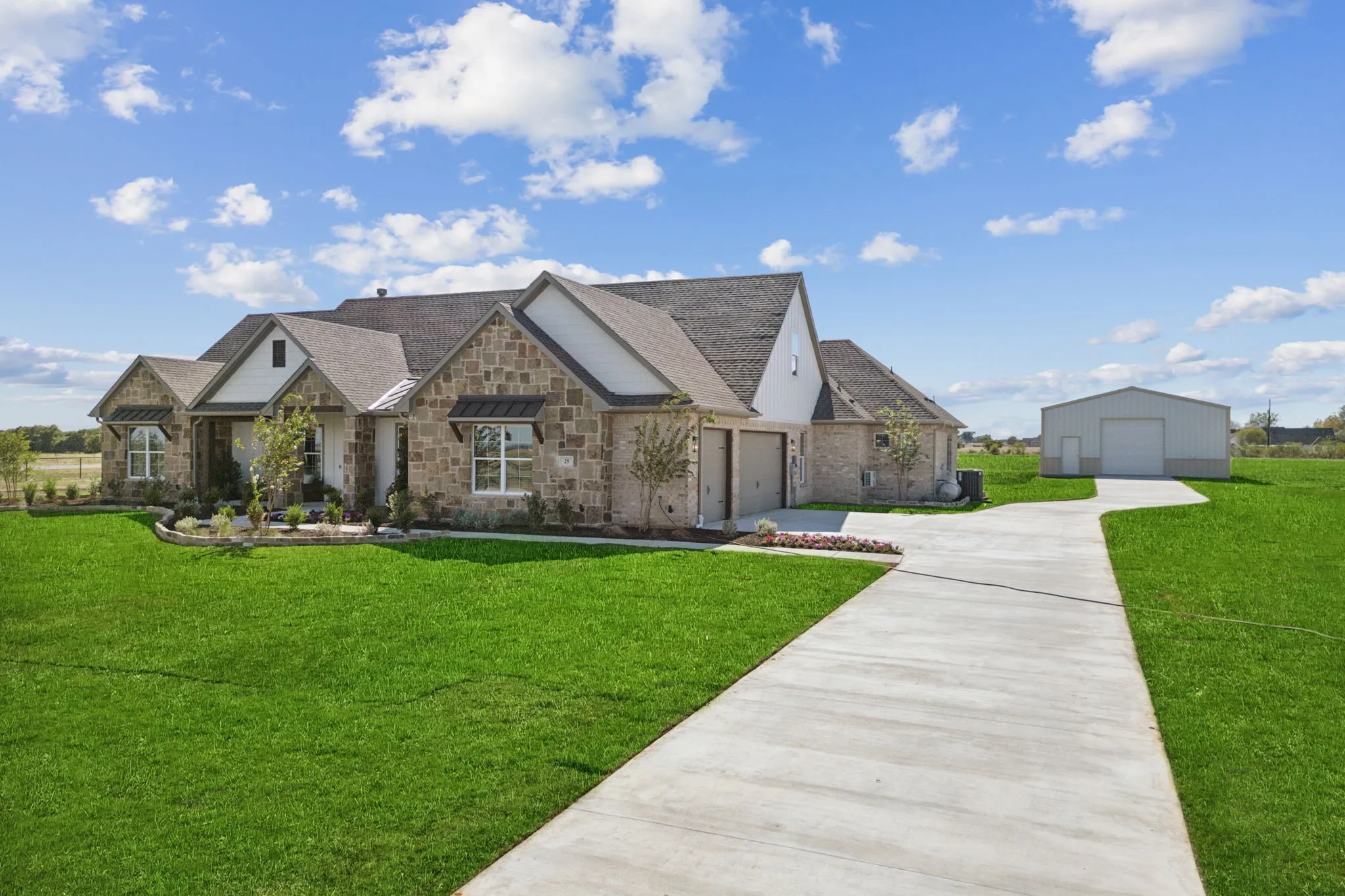 Stone and brick exterior with white trim accents and dark roofing