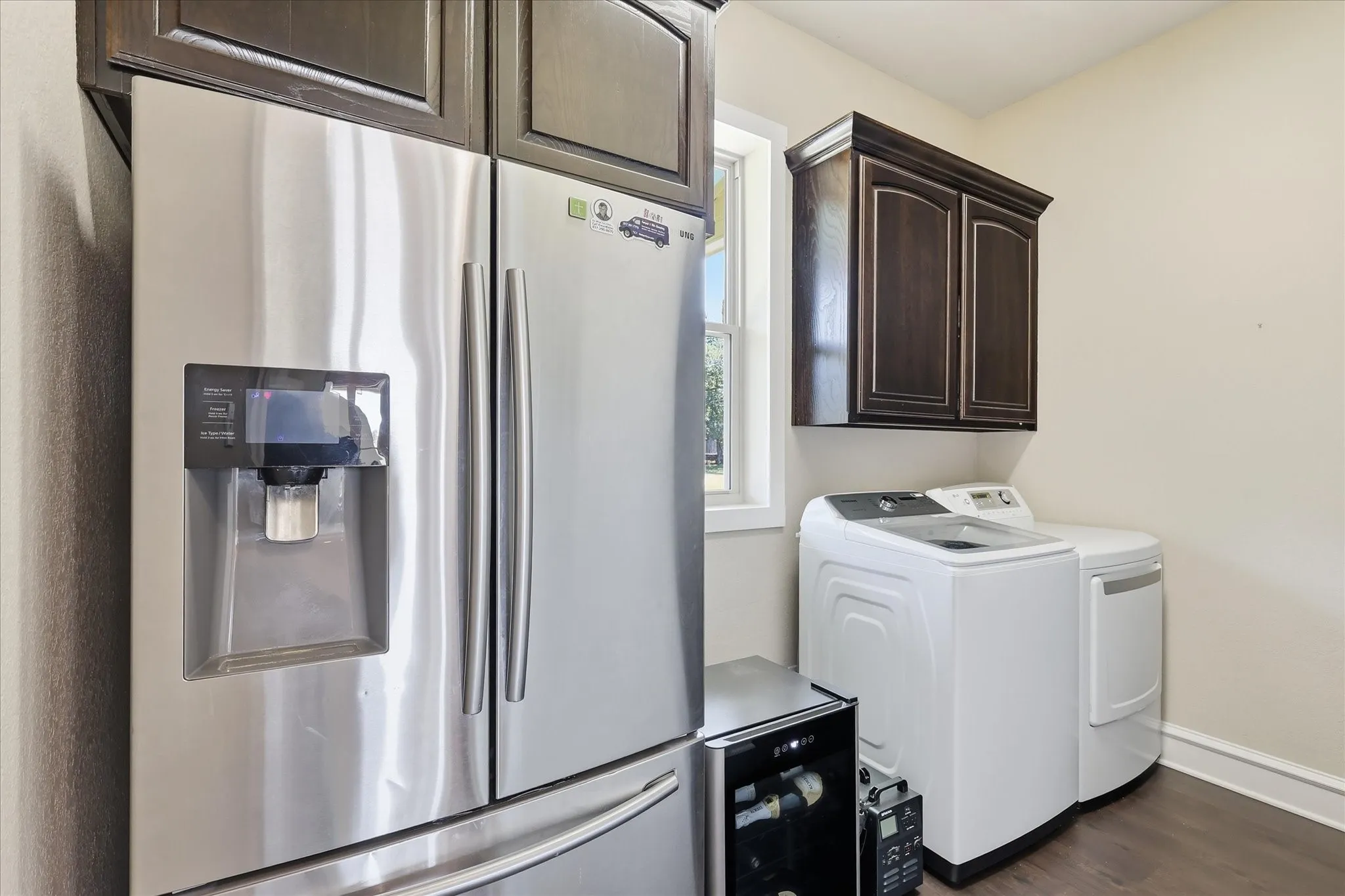 Large Laundry Suite with Secondary Fridge Space, Washer and Dryer, and Plumbing for Sink.