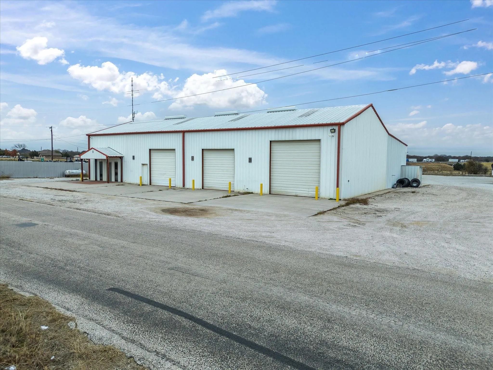 Commercial building featuring a white metal exterior and red trim