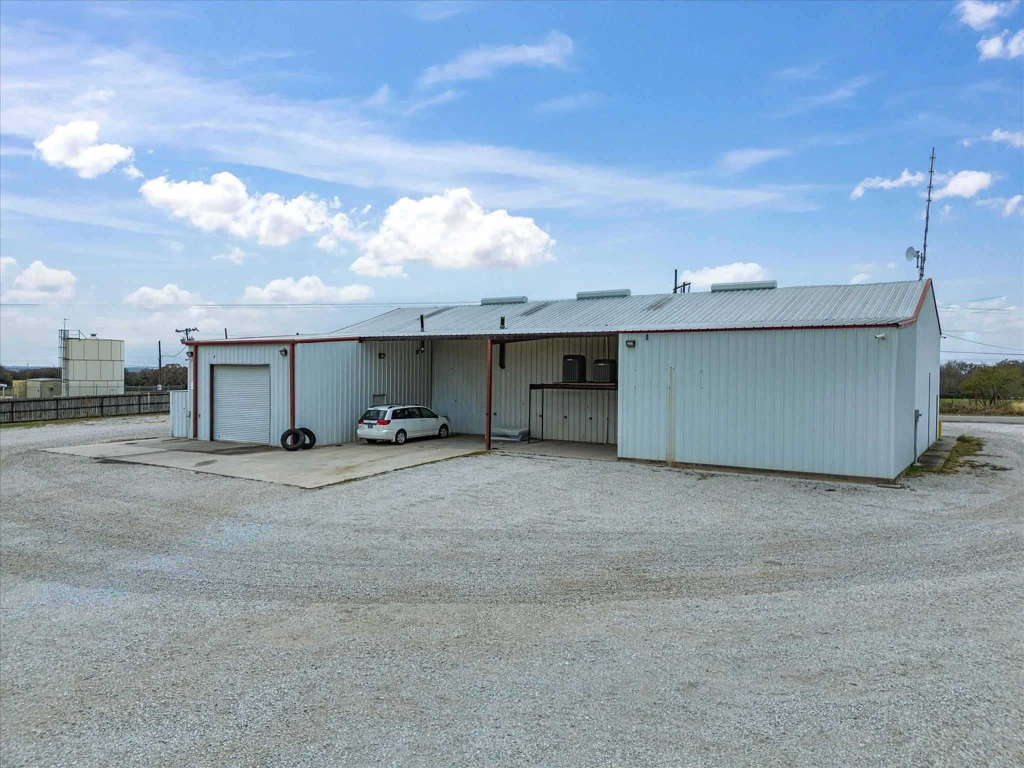 Metal-sided structure featuring a standing seam metal roof and a large overhead door