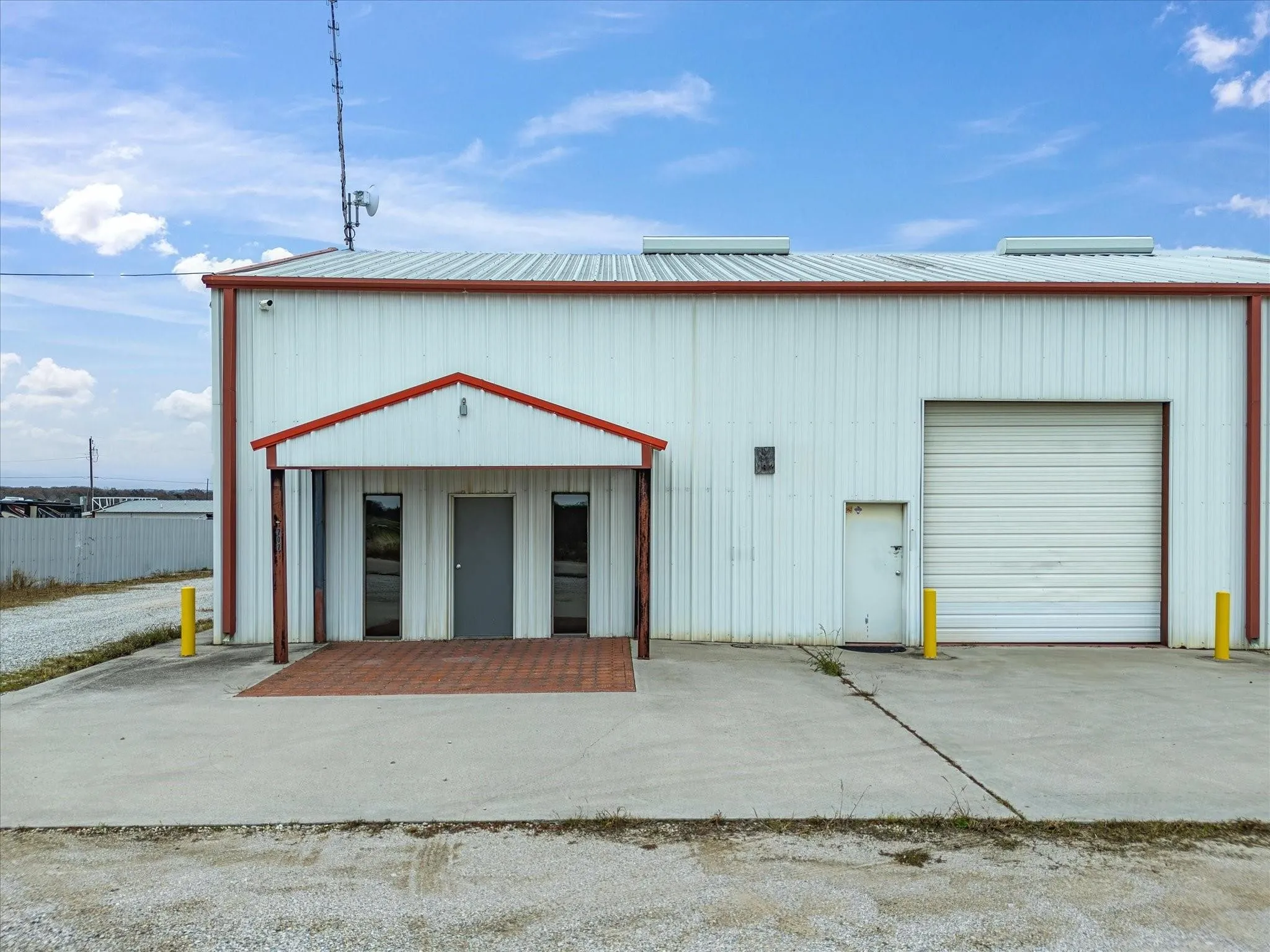 Industrial-style building featuring a corrugated metal exterior, red trim, and a prominent loading dock