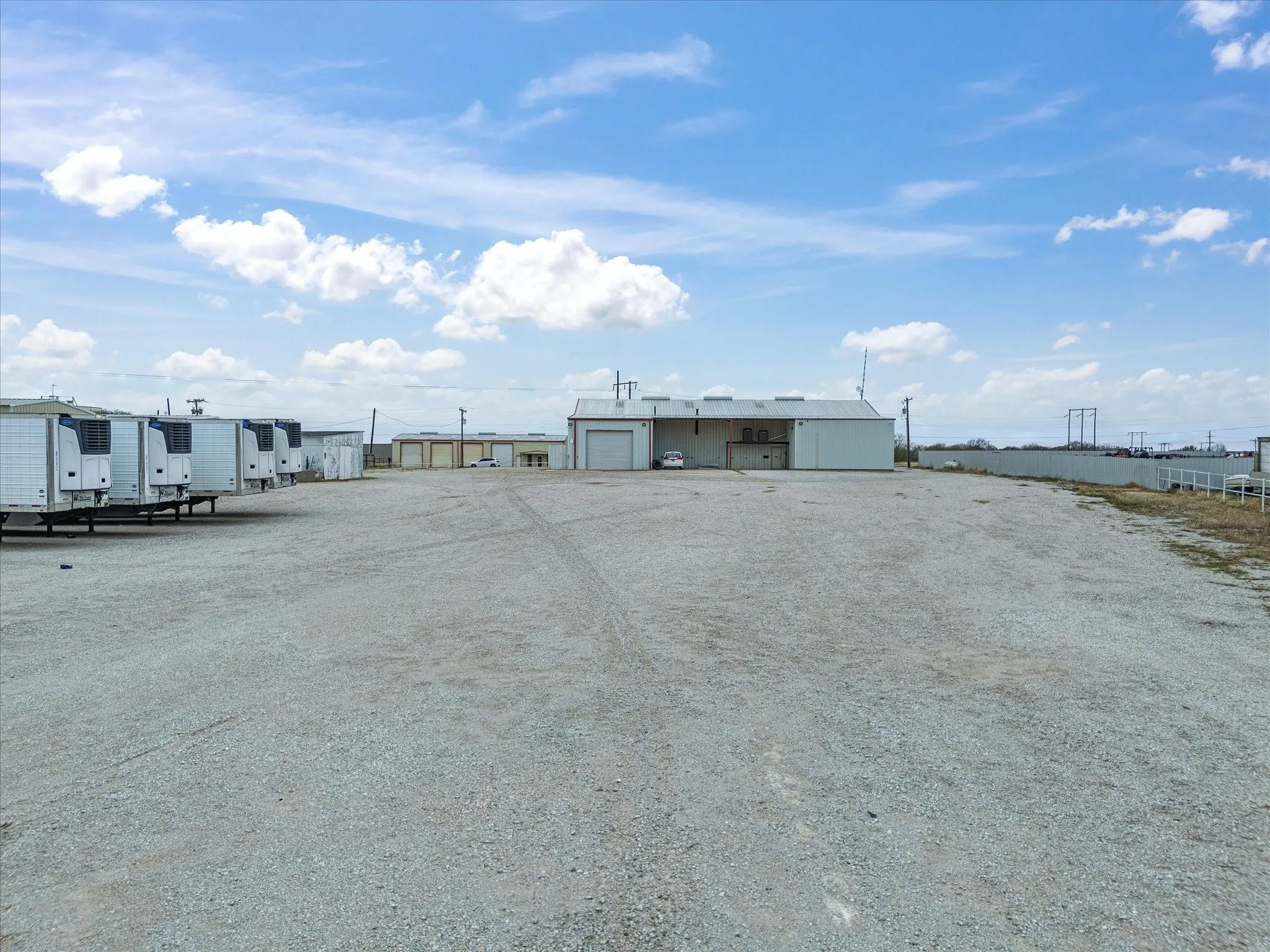 Expansive gravel lot featuring multiple storage facilities