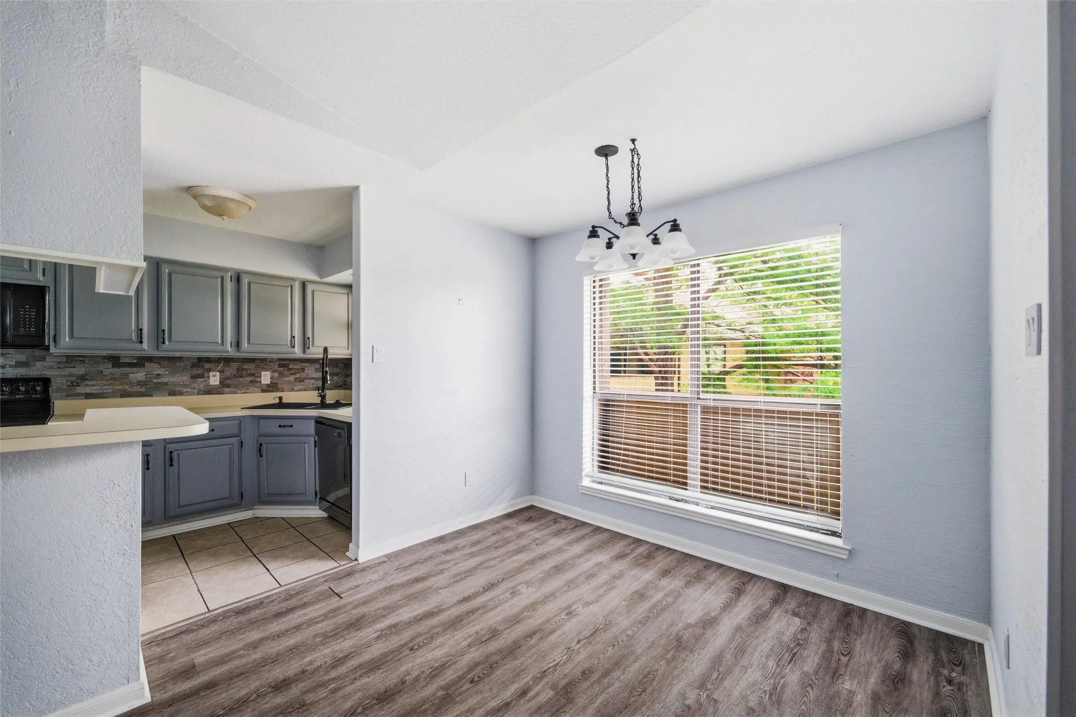 Dining area featuring wood-finish flooring and a contemporary chandelier