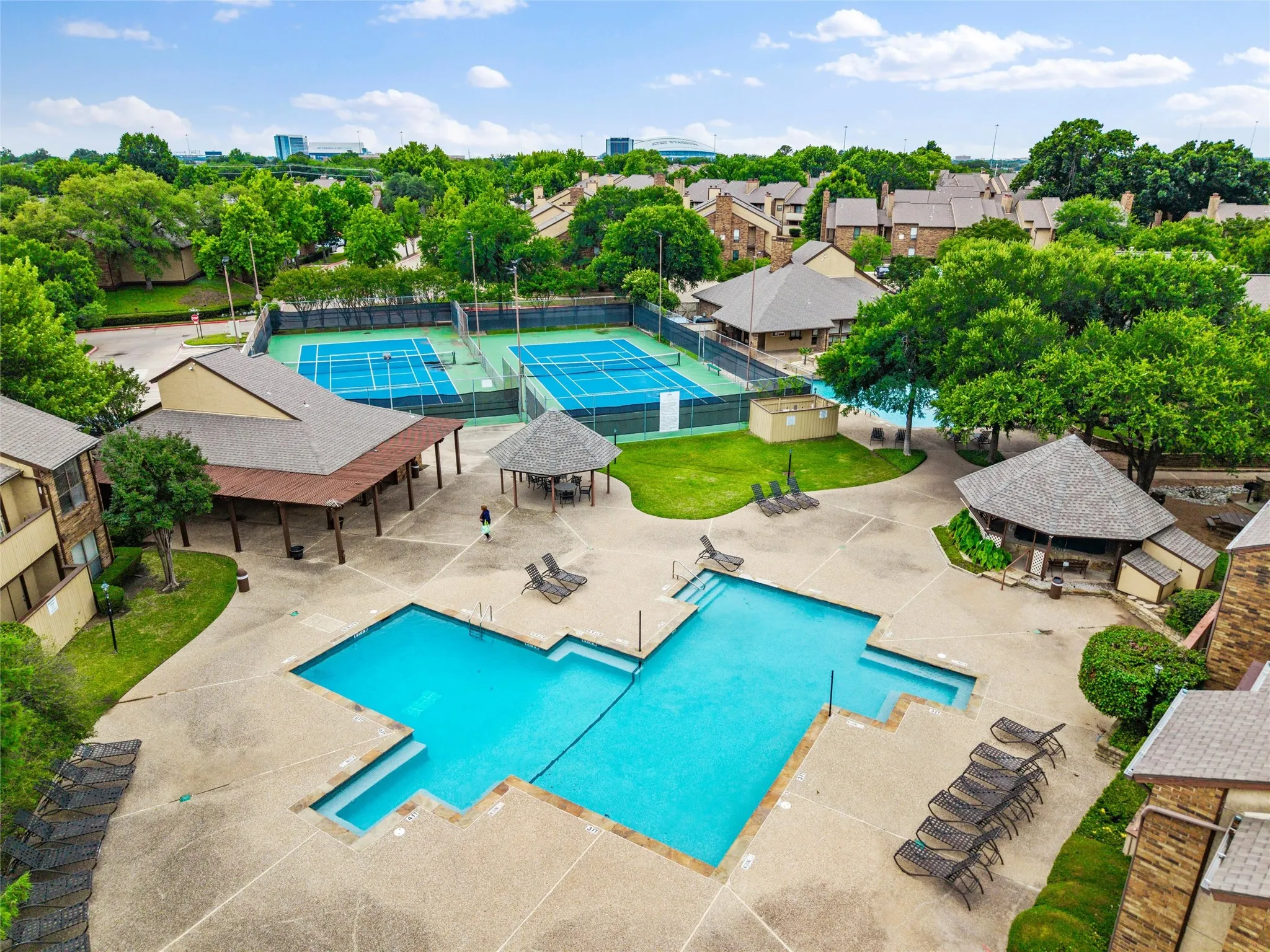 Community pool area with integrated spa, adjacent to multiple tennis courts