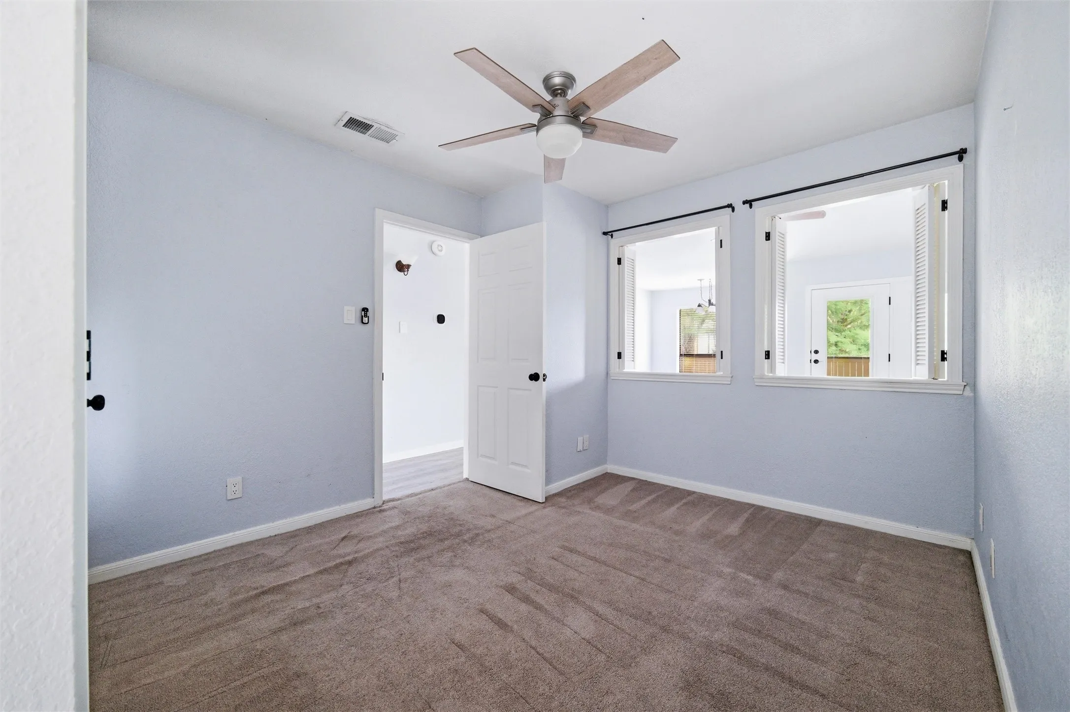 Neutral-toned carpet flooring in a room featuring light blue walls