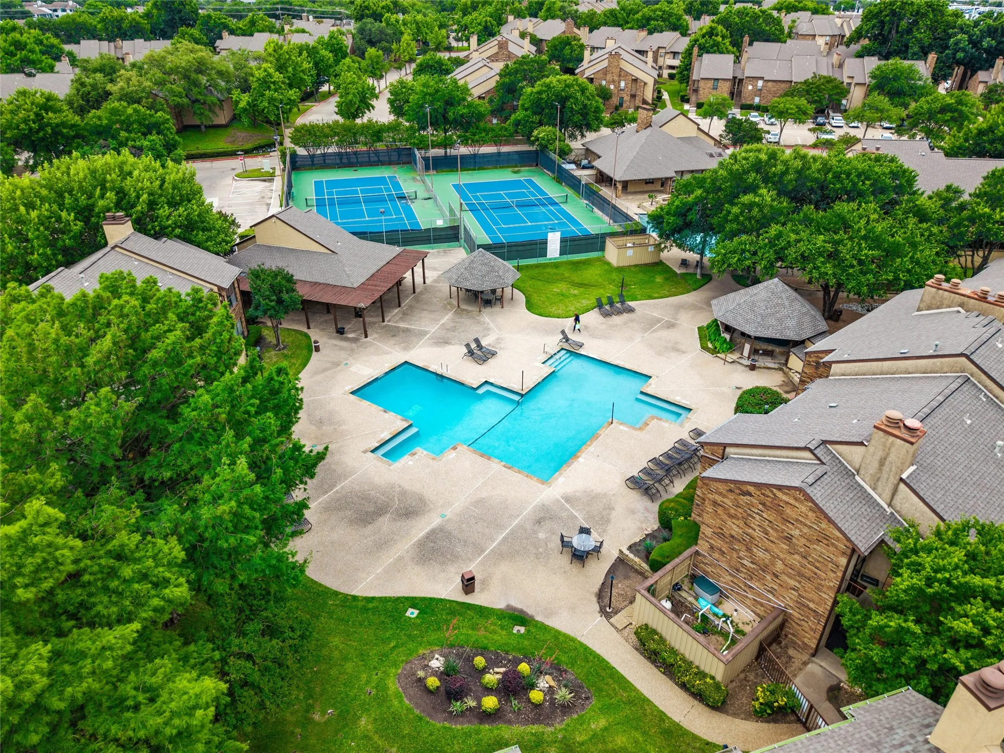 Community amenities featuring two tennis courts, a swimming pool with ample deck space, two shaded gazebos, and surrounding green spaces