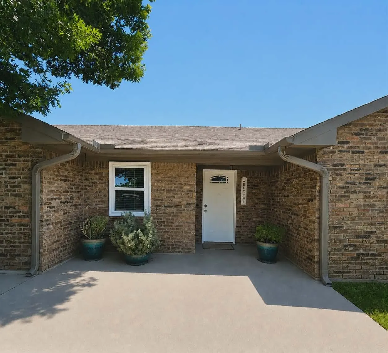 Brick exterior with a Front porch with overed entry, white front door, and a single window with white trim