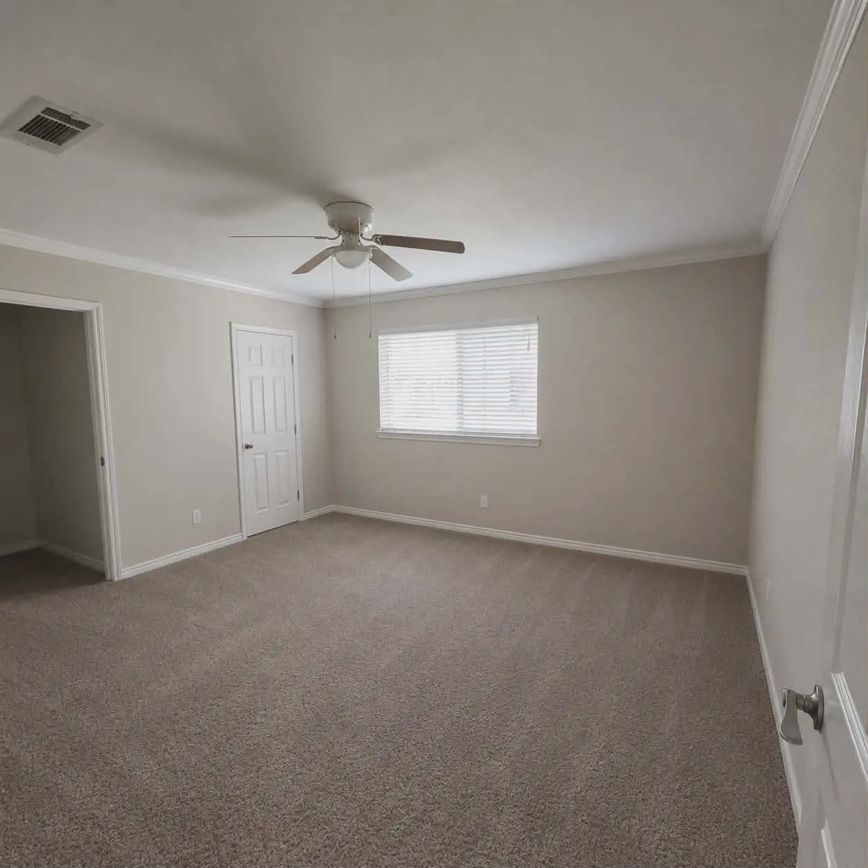Carpeted room featuring a ceiling fan with light, crown molding, baseboards, and a window with blinds-This photo was taken before family moved in