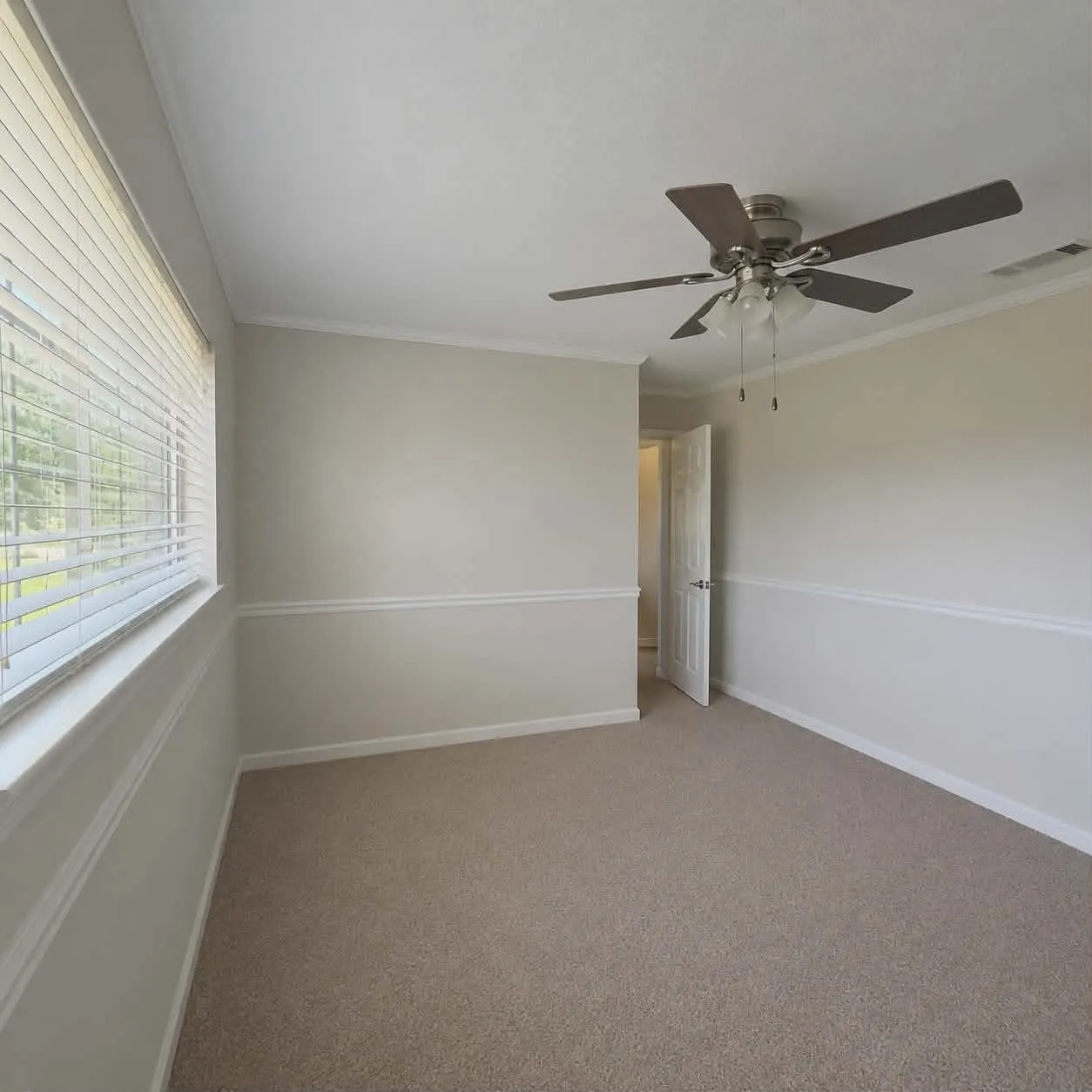 Bedroom 3-Carpeted room featuring a ceiling fan with integrated lighting, a window with blinds, and decorative chair rail molding-This photo was taken before family moved in