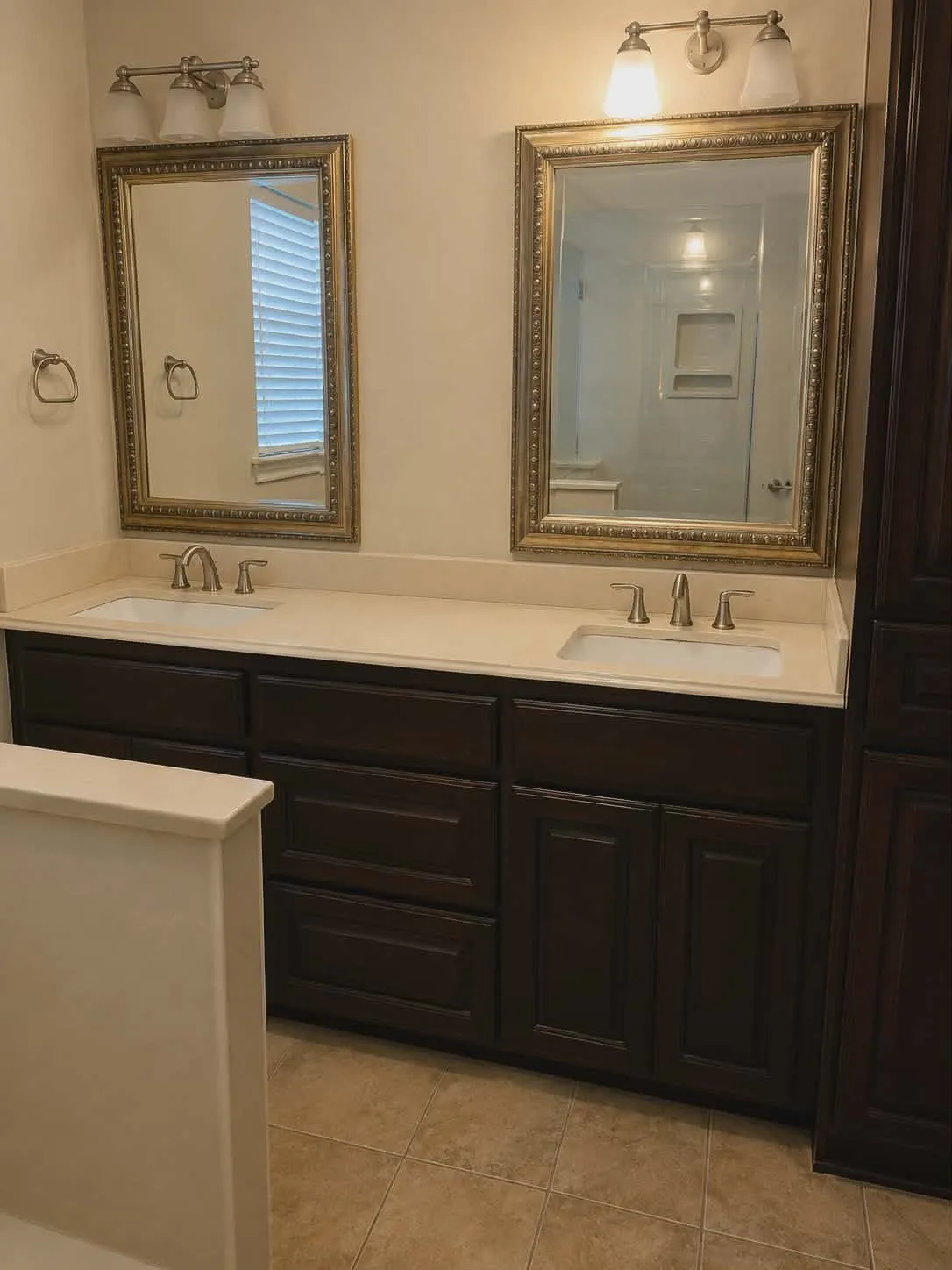 Dual vanity with dark wood-finish cabinetry and light-toned countertops-This photo was taken before family moved in