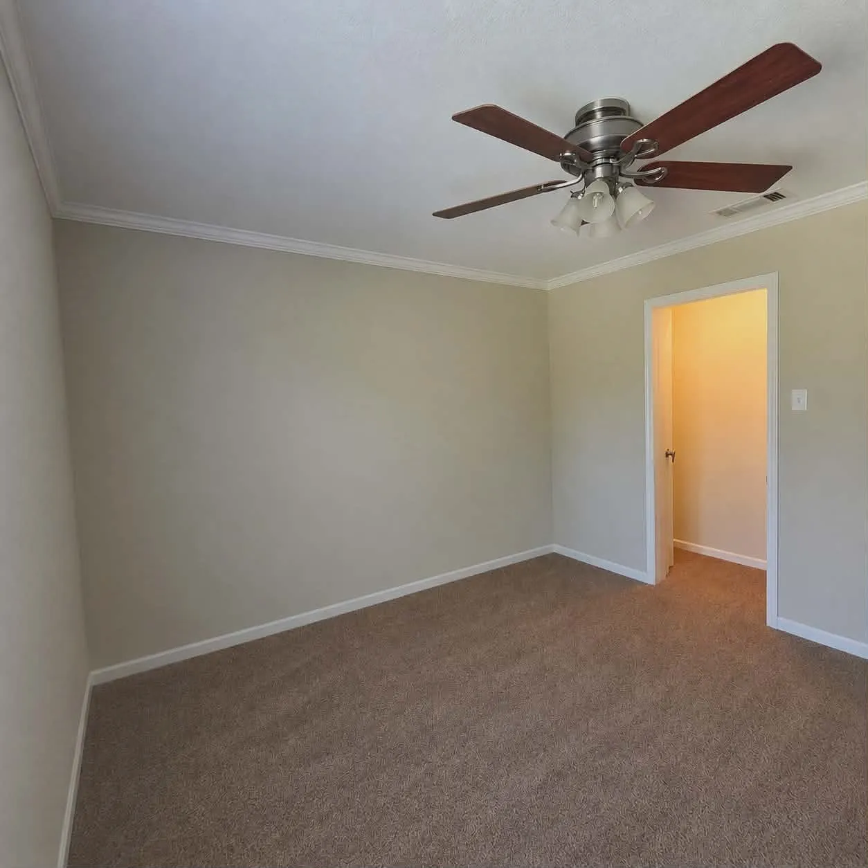 Bedroom 4-Neutral wall color with crown molding, carpet flooring, and a ceiling fan with light fixture-This photo was taken before family moved in