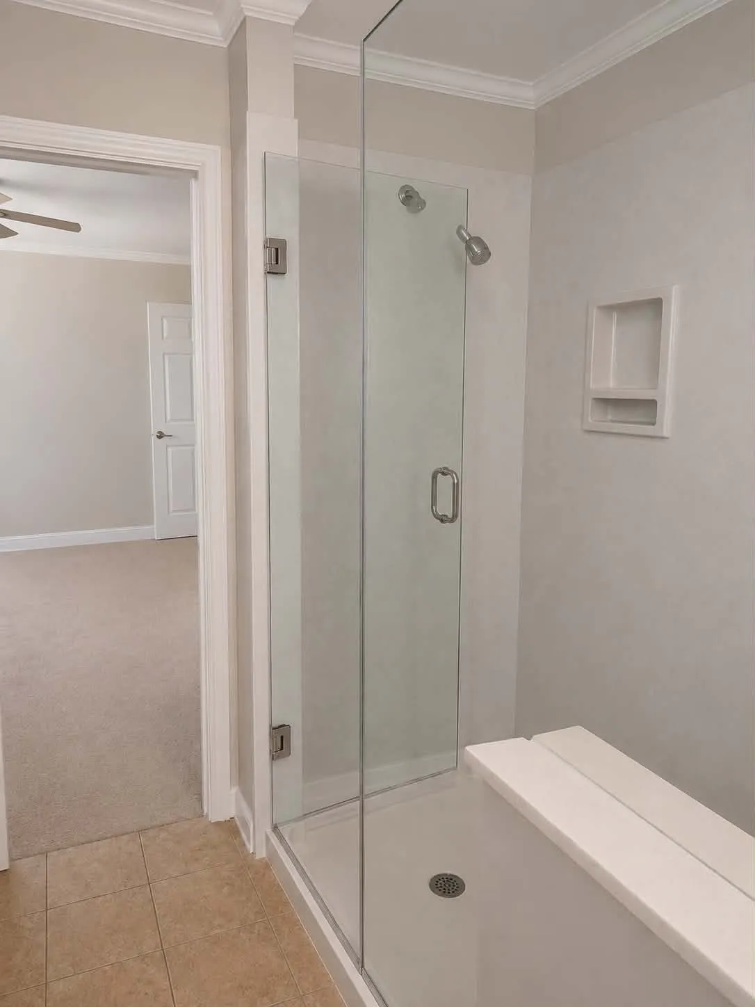 Walk-in shower with clear glass enclosure and built-in bench-This photo was taken before family moved in