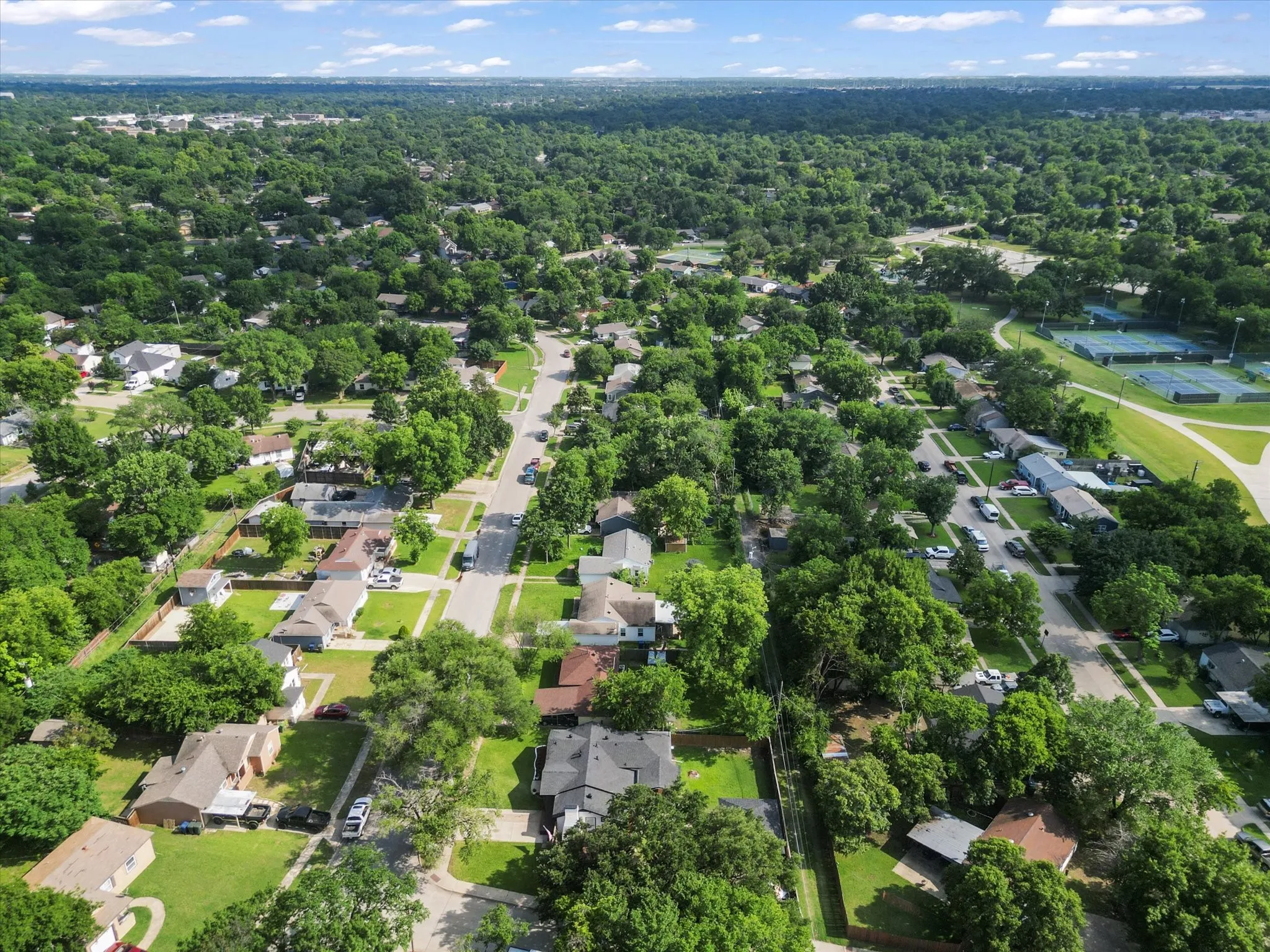 Aerial perspective showcasing a residential neighborhood with extensive tree canopy