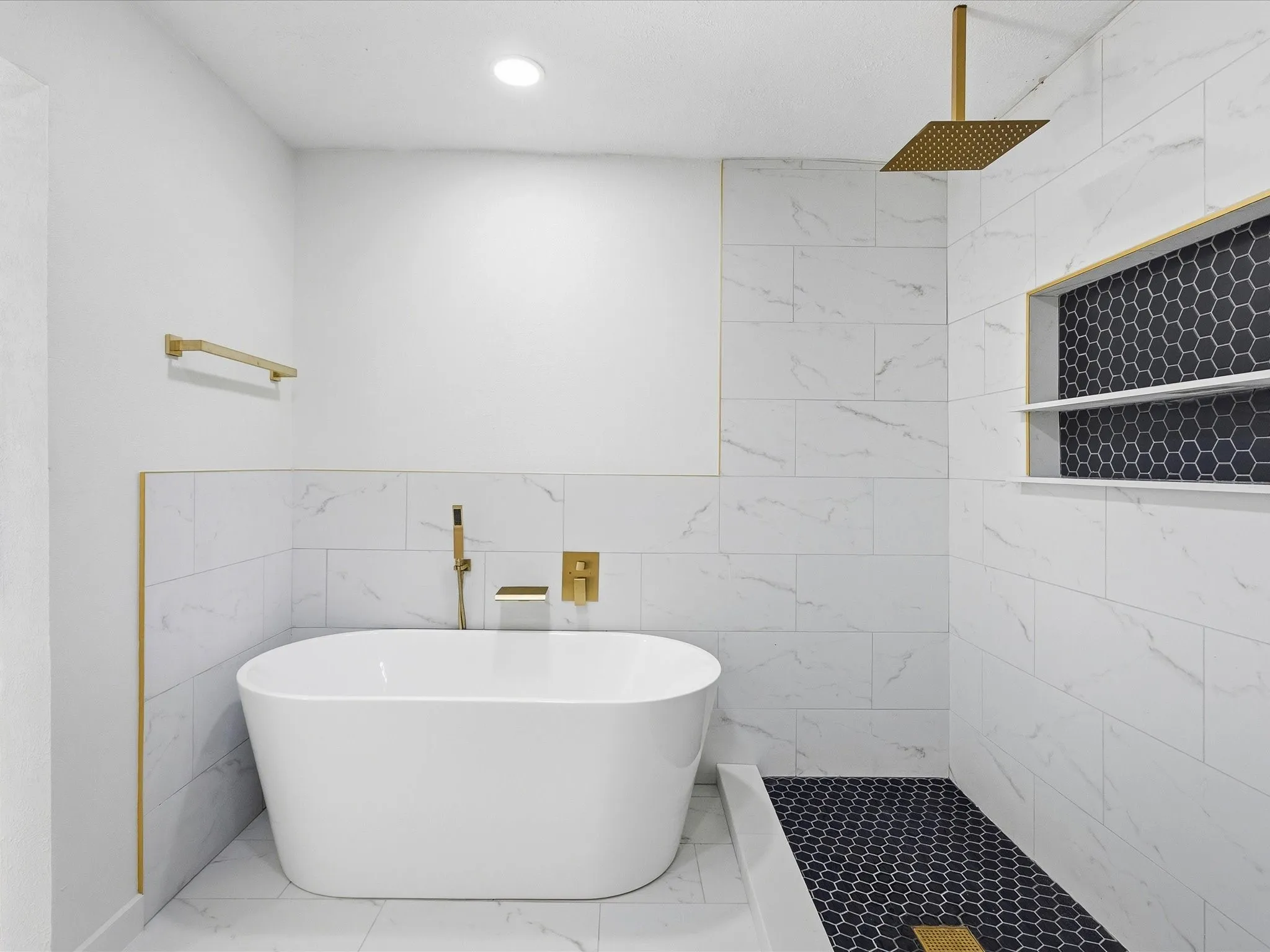 Freestanding soaking tub with gold-finish fixtures
