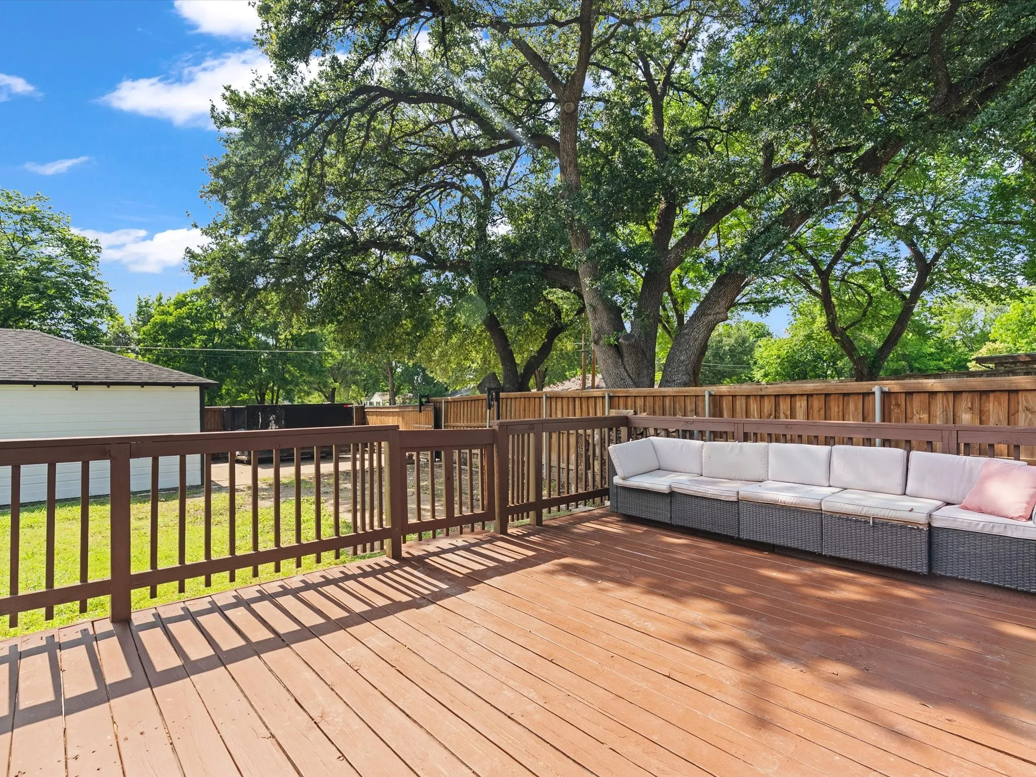 Expansive wood deck with a full railing and a wood privacy fence