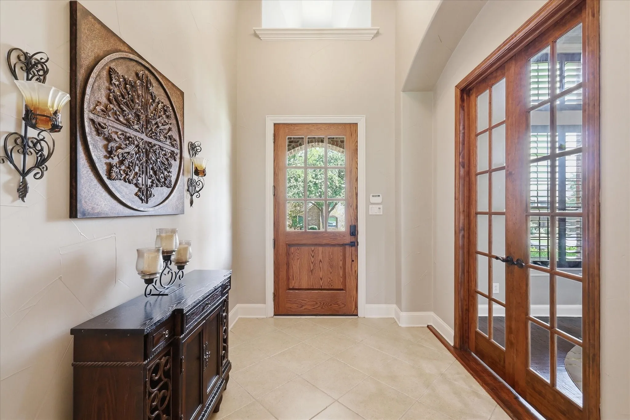 Entryway featuring a paneled wood-finish door with glass inserts, recessed lighting, and tile flooring
