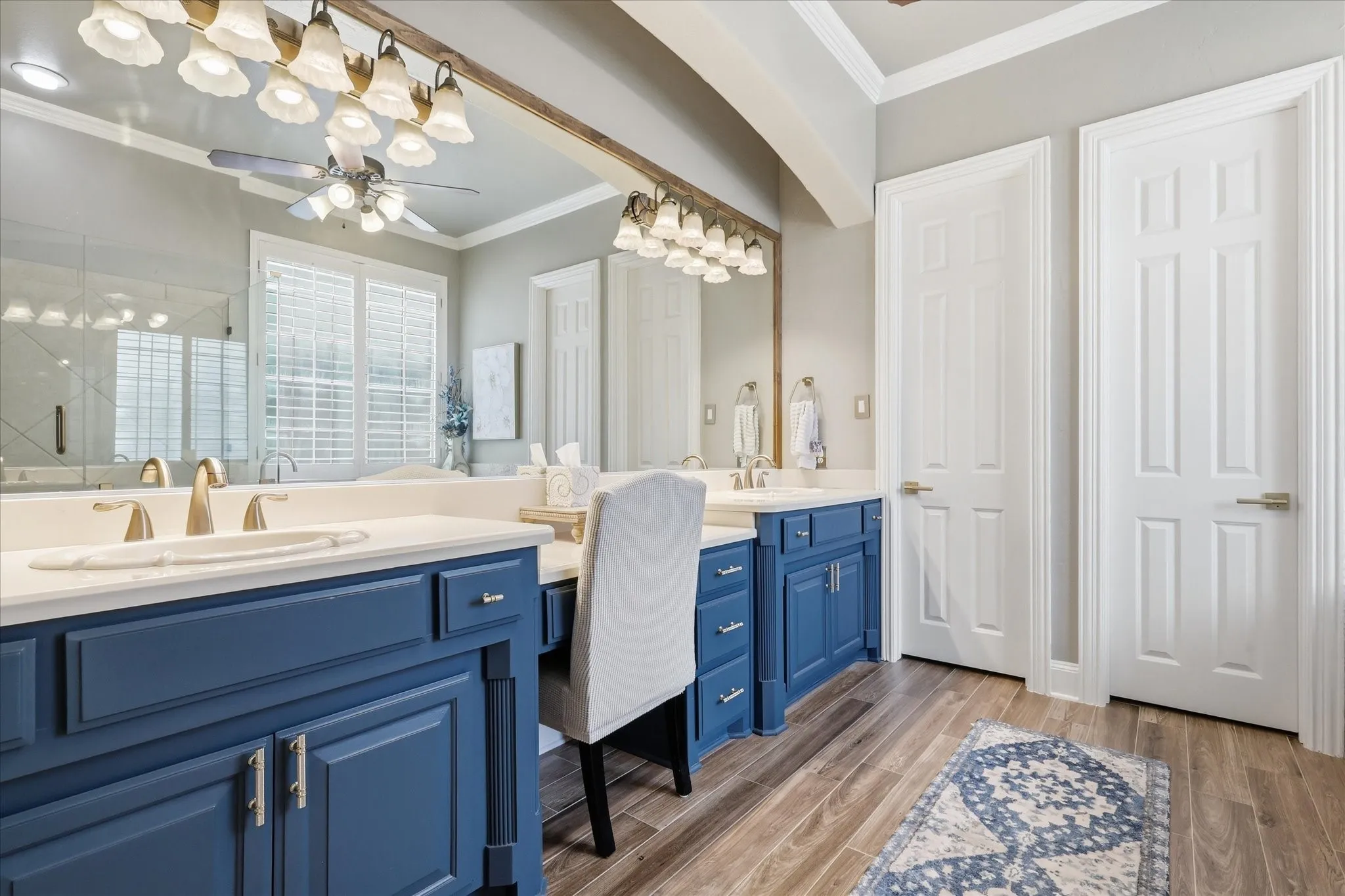 Dual vanity with blue cabinetry, undermount sinks, and light countertops