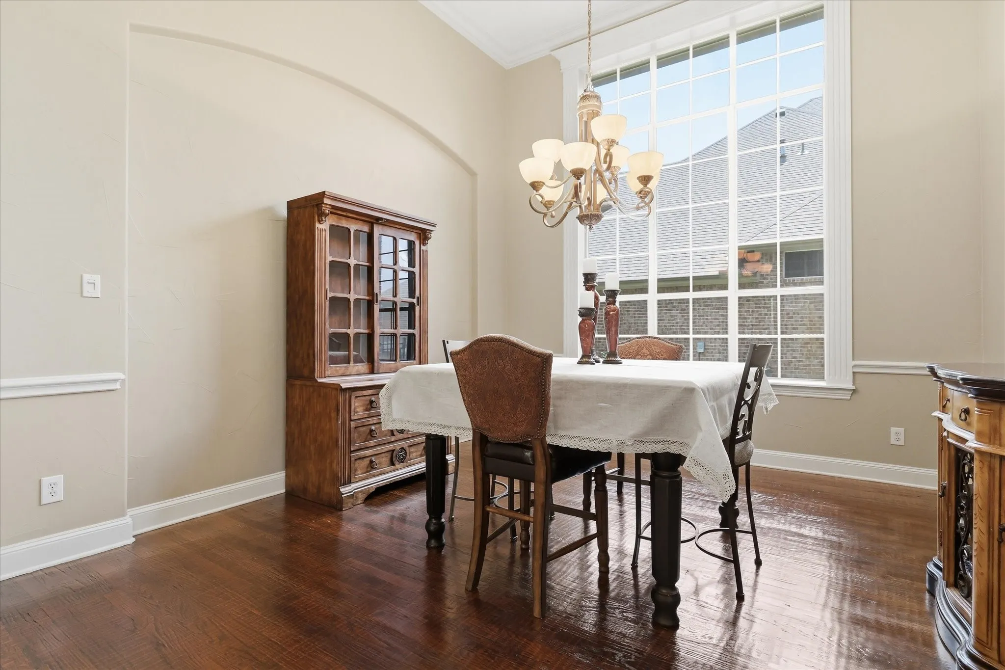 Room featuring expansive multi-pane windows, wood-finish flooring, and high ceilings