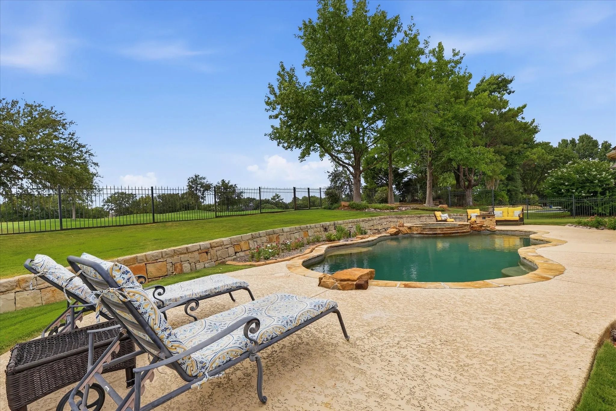 Freeform swimming pool with a stone coping and integrated stone features