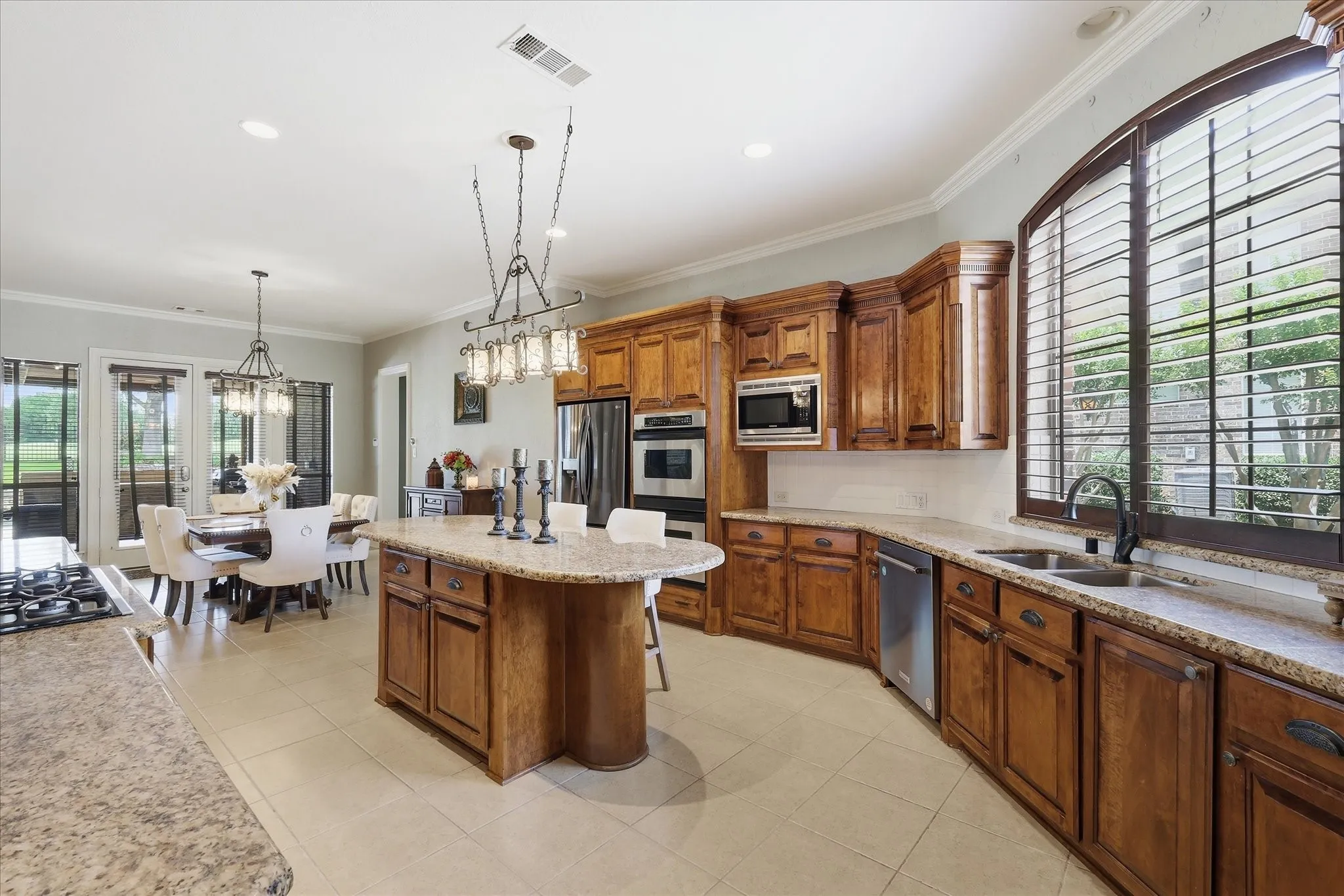 Kitchen featuring wood cabinetry, granite countertops, tile flooring, and stainless steel appliances
