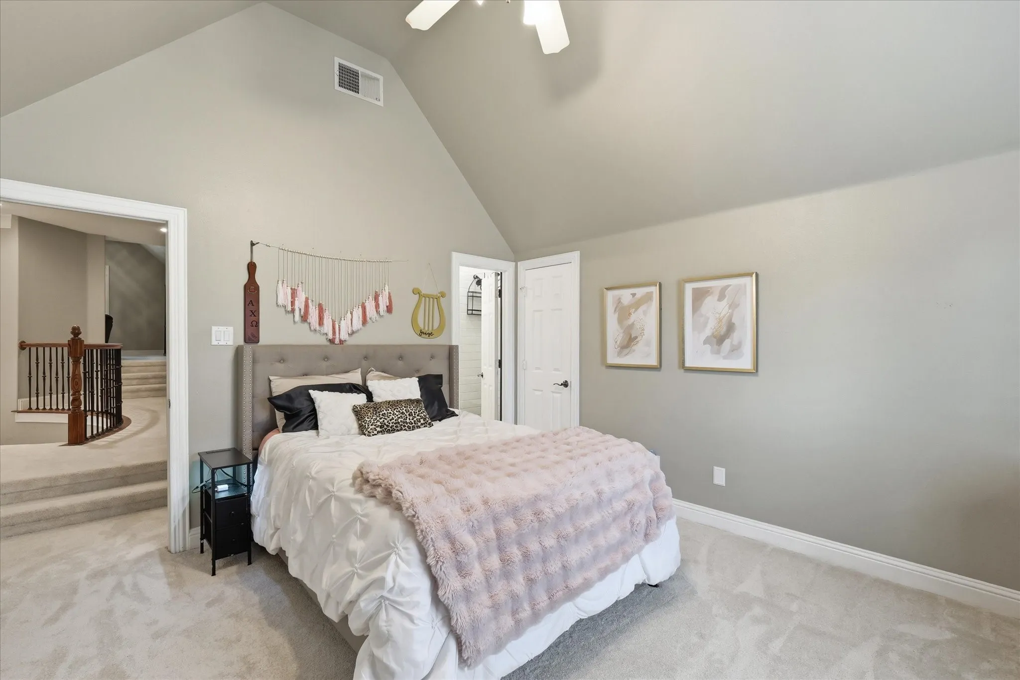 Vaulted ceiling room featuring light gray wall paint, neutral carpeting, and a ceiling fan