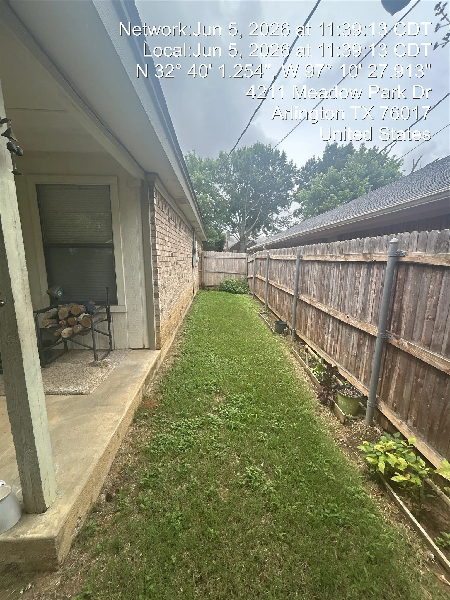 Side yard featuring a manicured lawn, full-height wooden privacy fence, and brick exterior