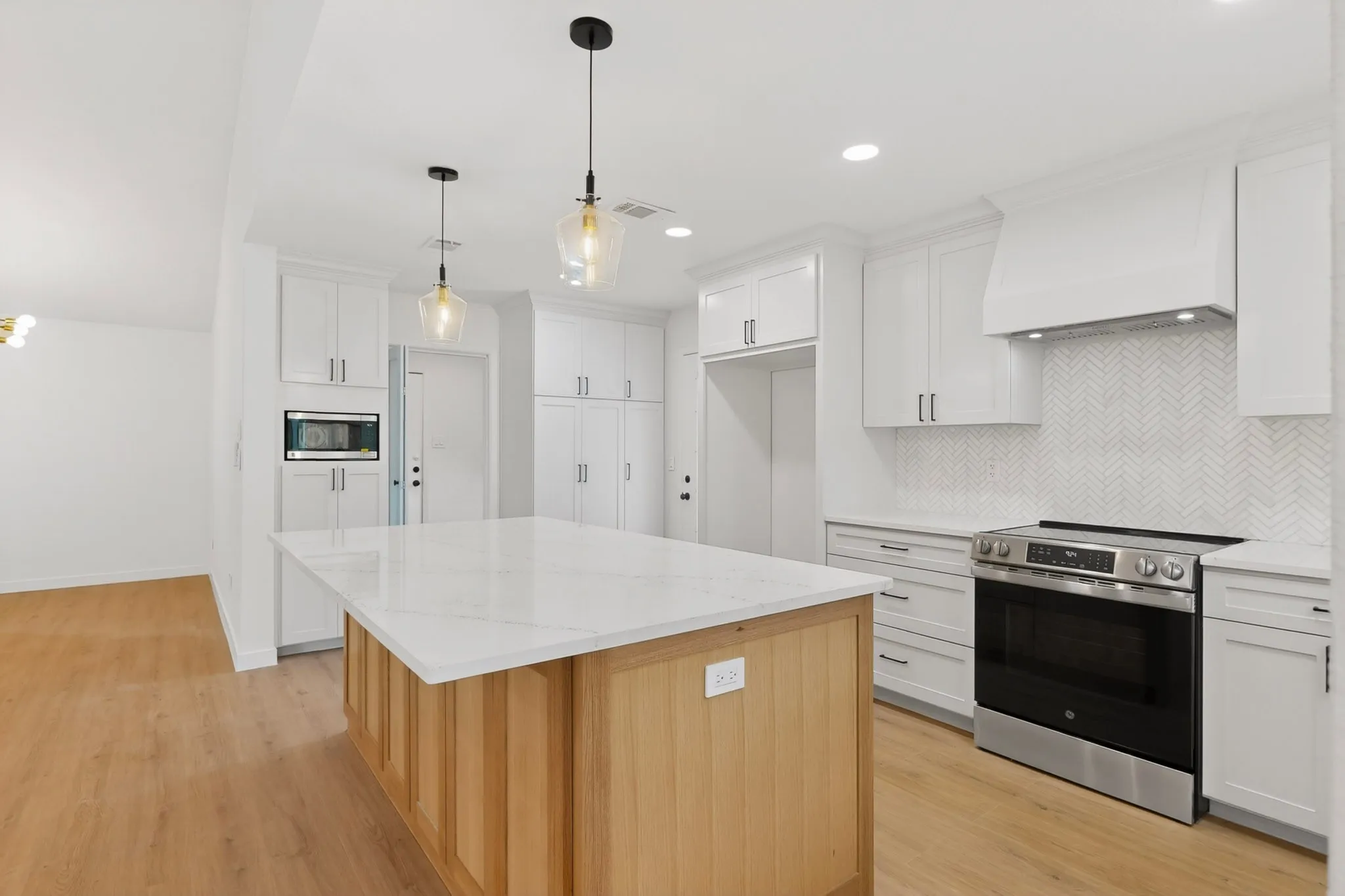 Spacious kitchen featuring a central island with a light wood base and a white countertop