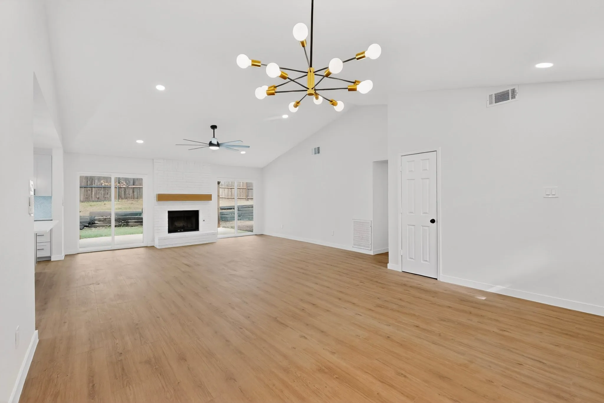 Spacious interior with vaulted ceilings, wood-finish flooring, and recessed lighting