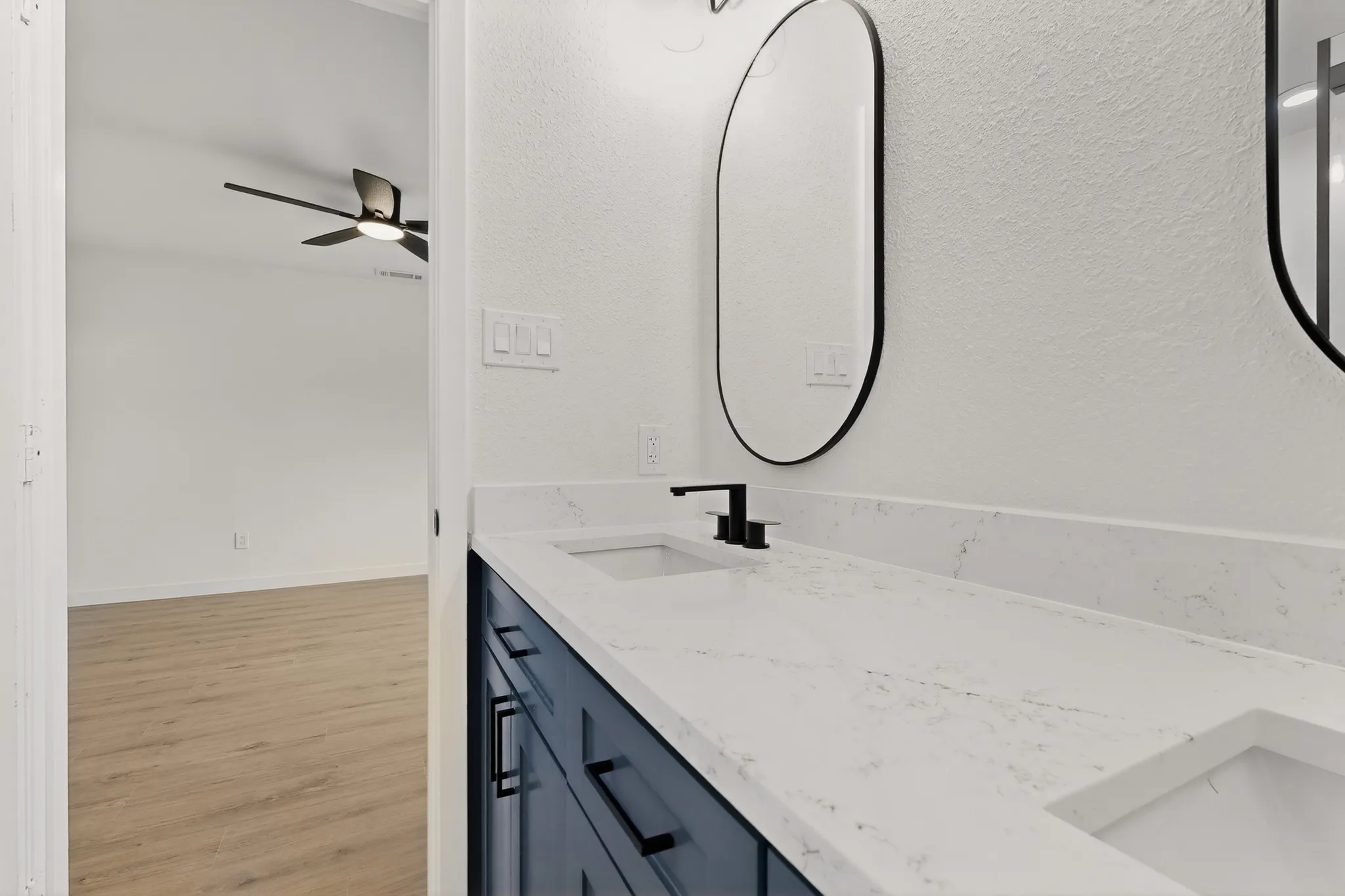Dual vanity with stone-finish countertop, undermount sinks, and matte black fixtures