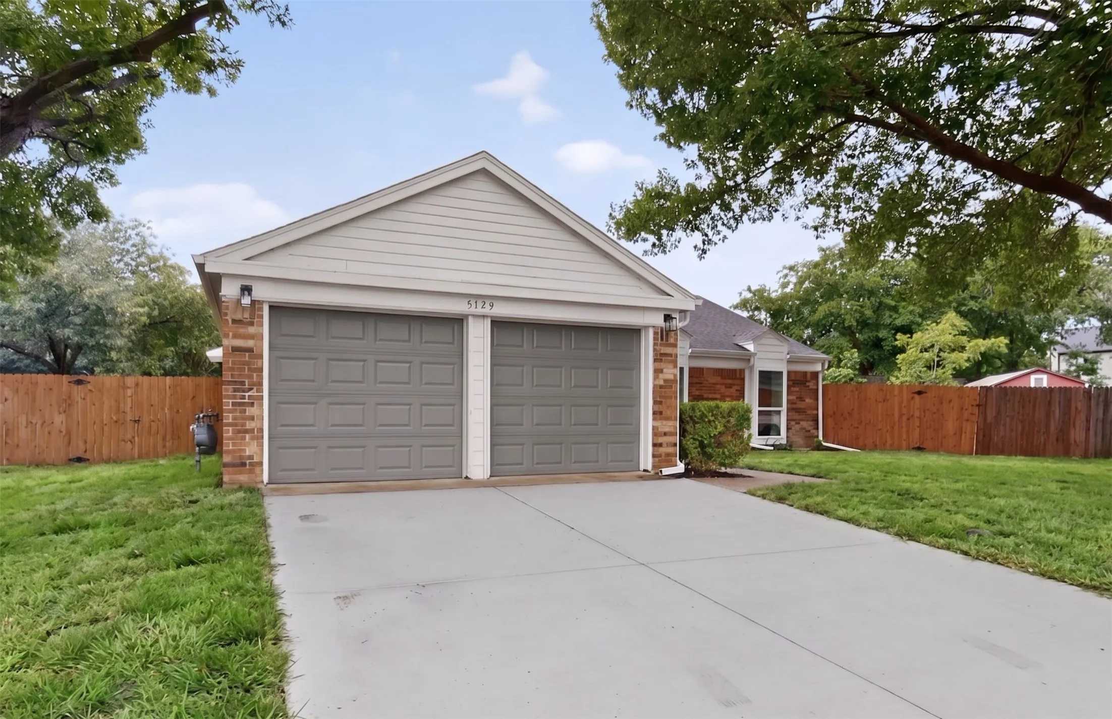 Brick and siding exterior featuring a two-car garage with gray doors