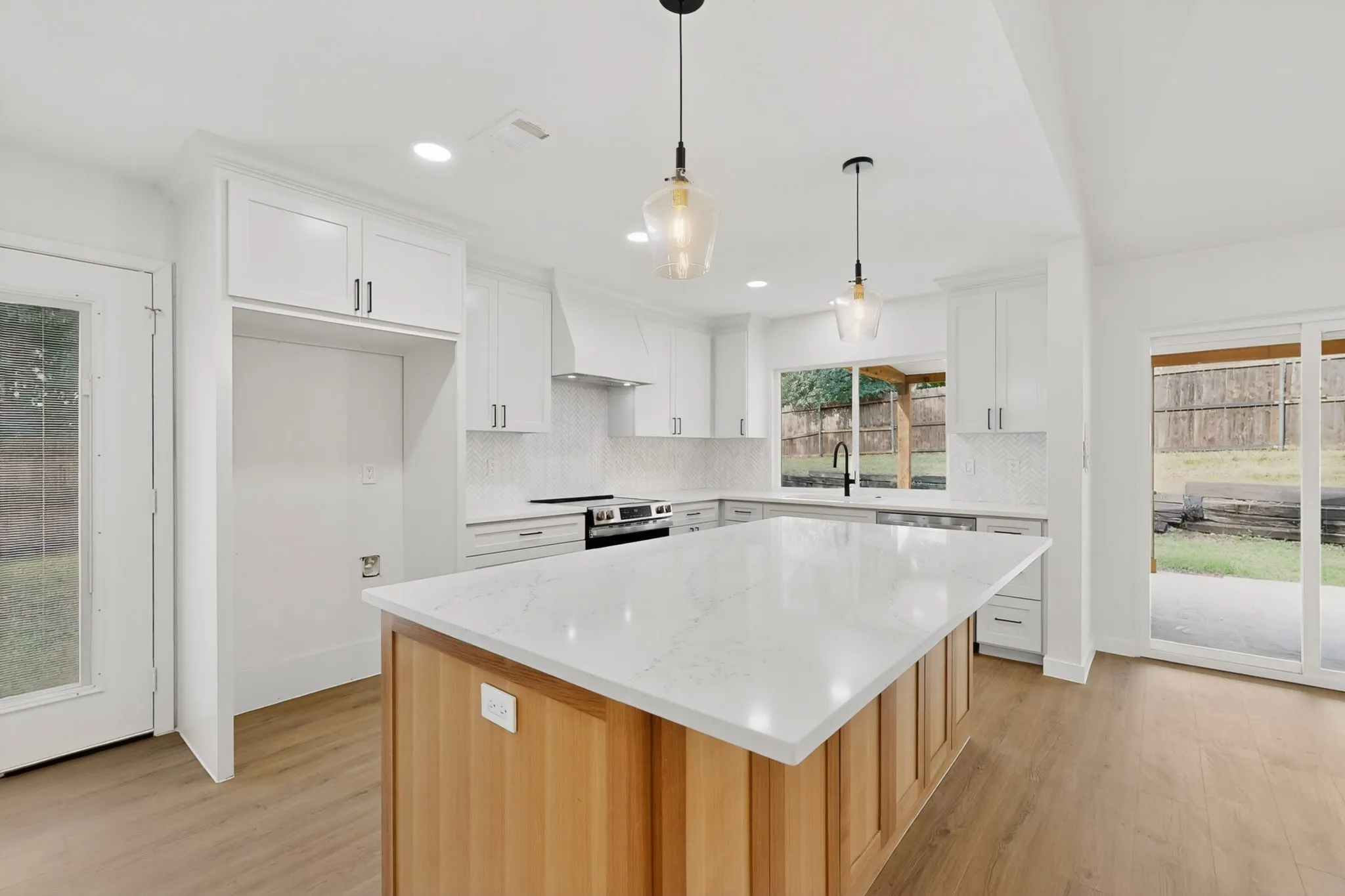 Contemporary kitchen featuring a large central island with a light wood base and a substantial countertop
