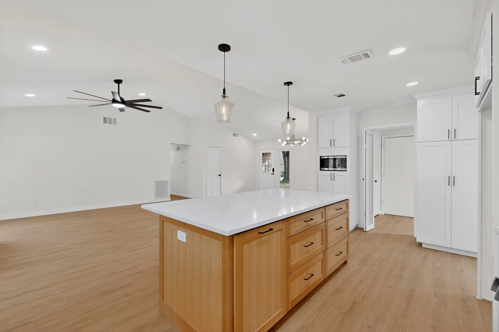 Kitchen island featuring a light wood-finish base and white countertop