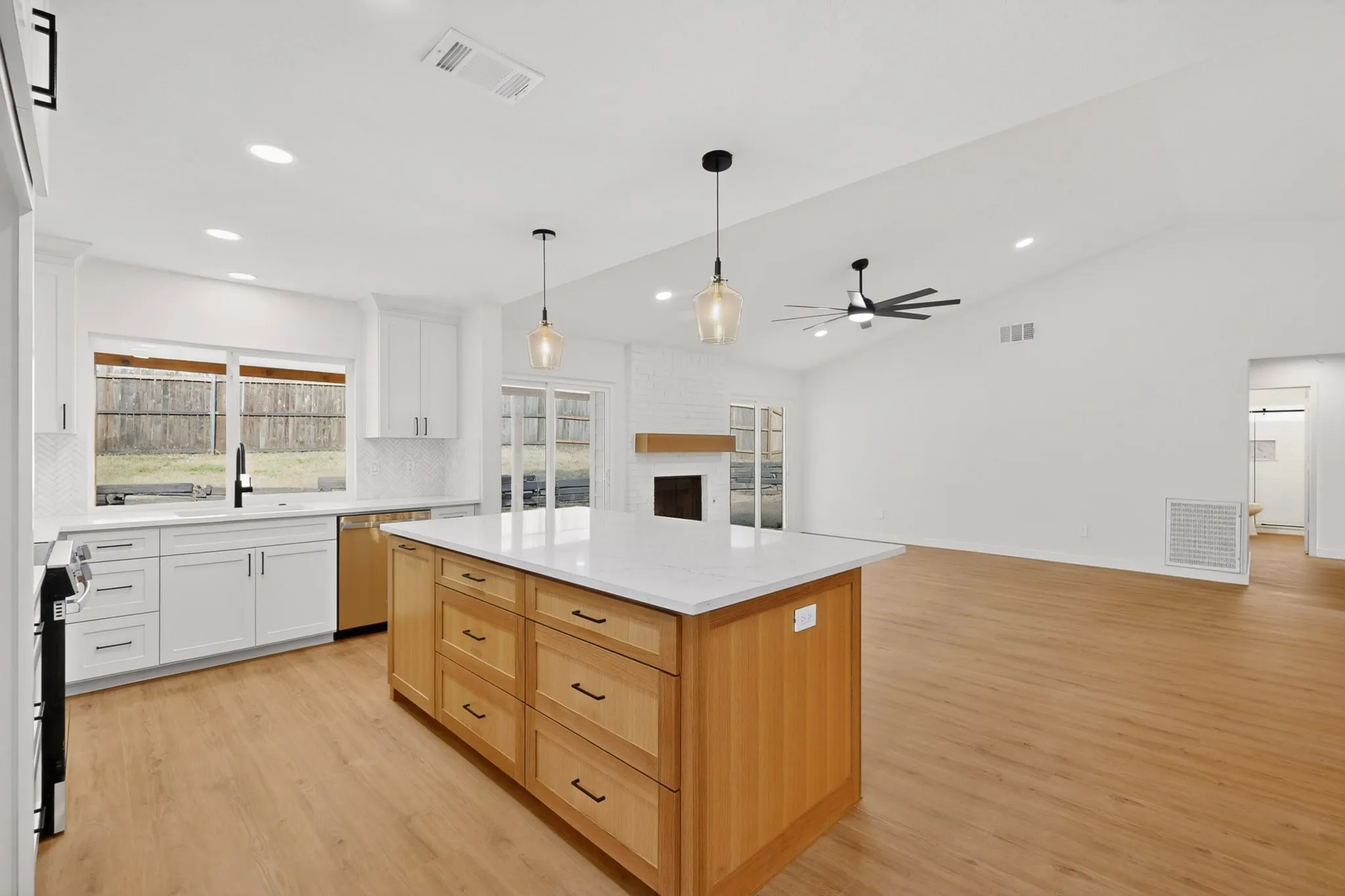 Open-concept kitchen and living area featuring a vaulted ceiling and wood-finish flooring
