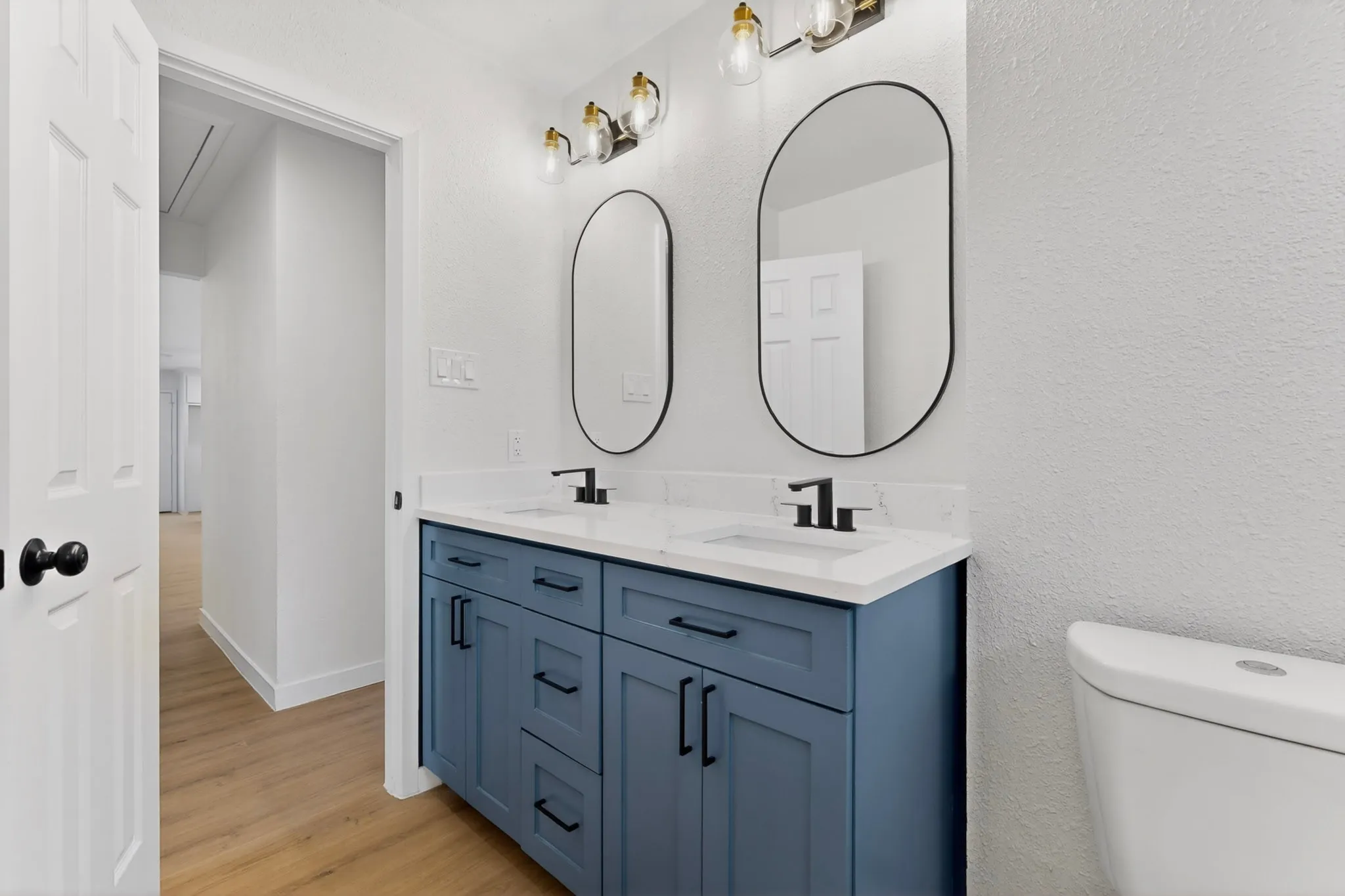 Bathroom featuring a double vanity with a blue cabinet base, white countertop, and dual sinks