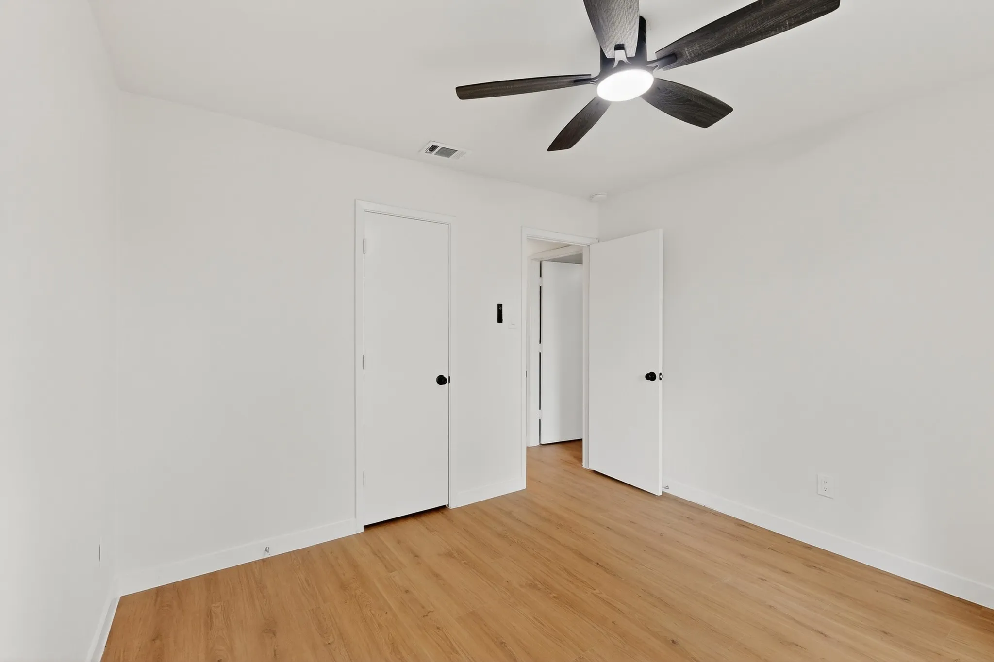 Neutral white walls complement the wood-finish flooring