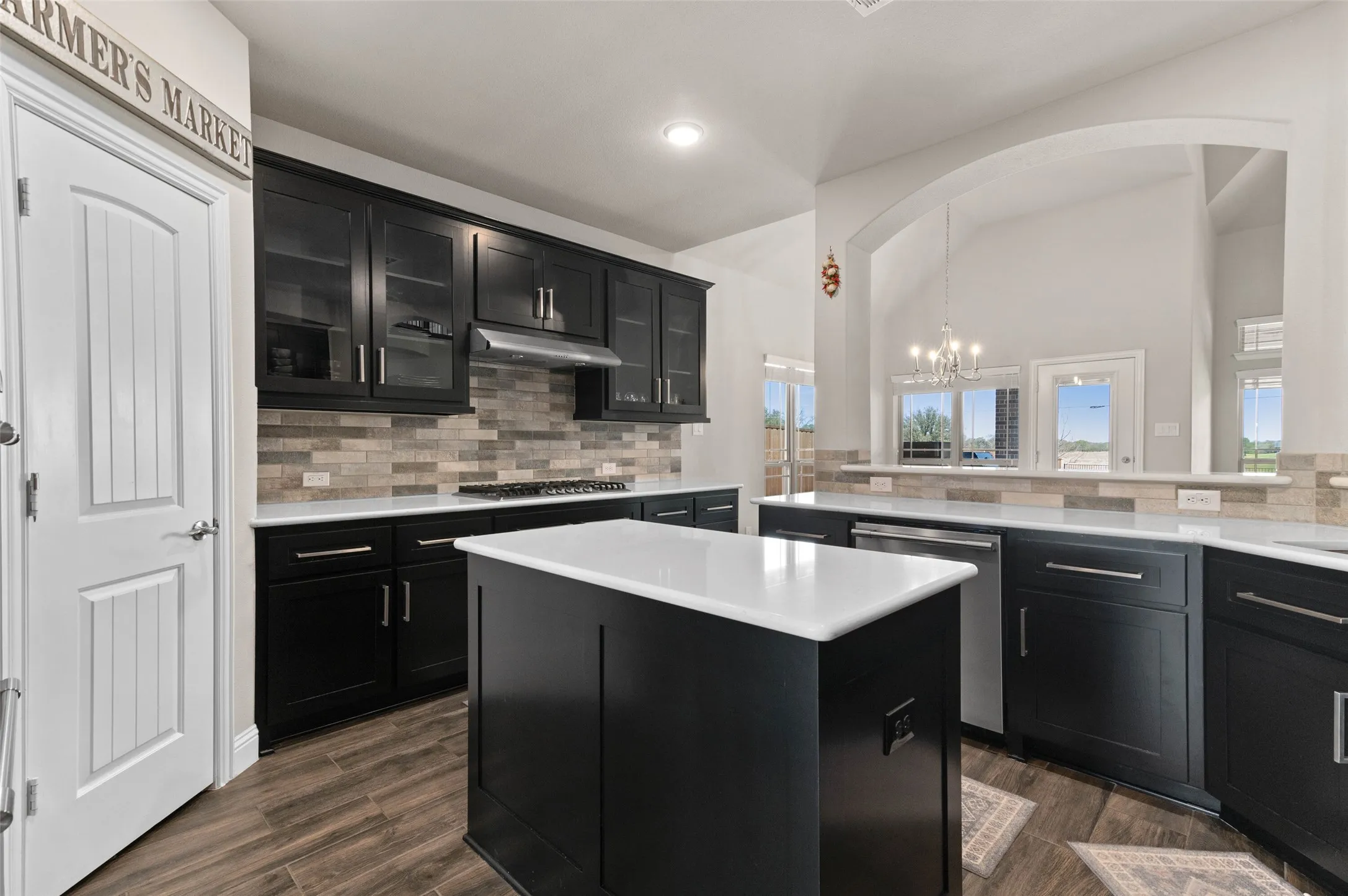 Large kitchen featuring a central island with a white countertop