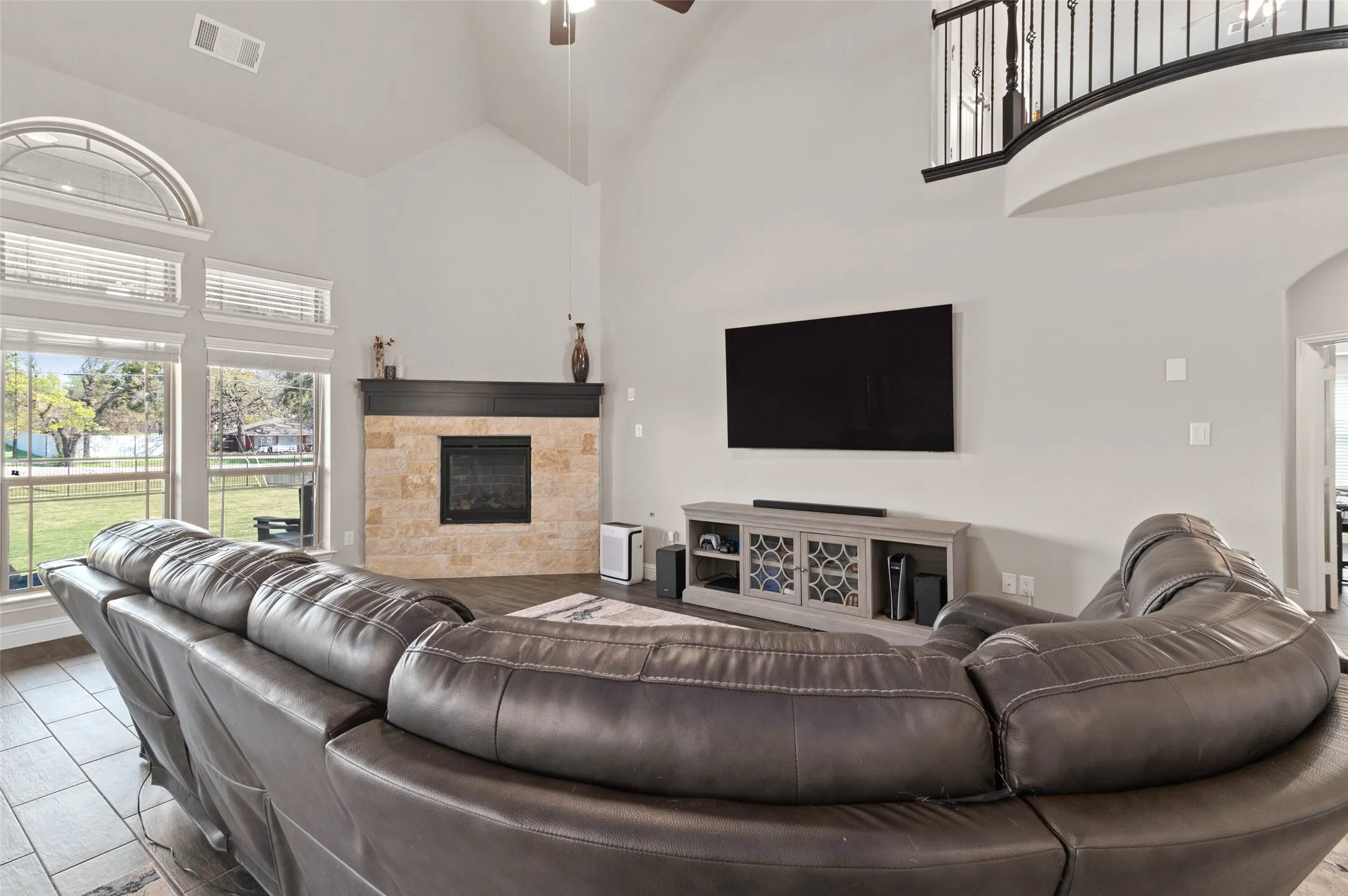 Spacious living area featuring a vaulted ceiling and an upper-level balcony with wrought iron railing